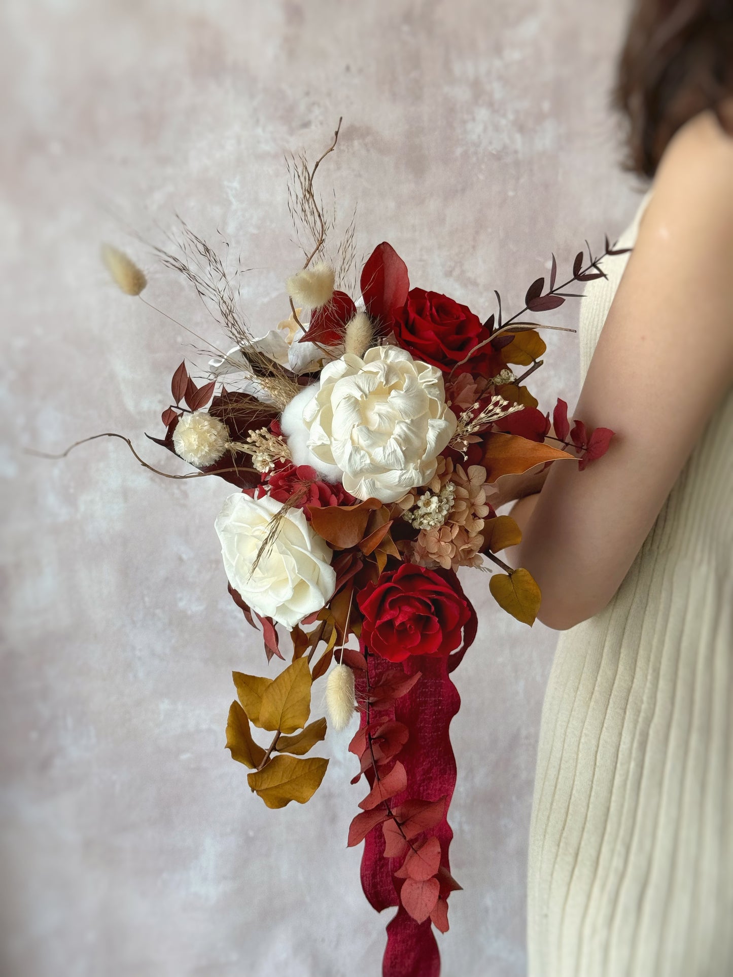 Side view showcasing the bouquet’s cascading silhouette, where the preserved flowers and foliage flow gracefully.
侧面视角展现瀑布式捧花的流畅线条,永生花与树叶自然垂坠。