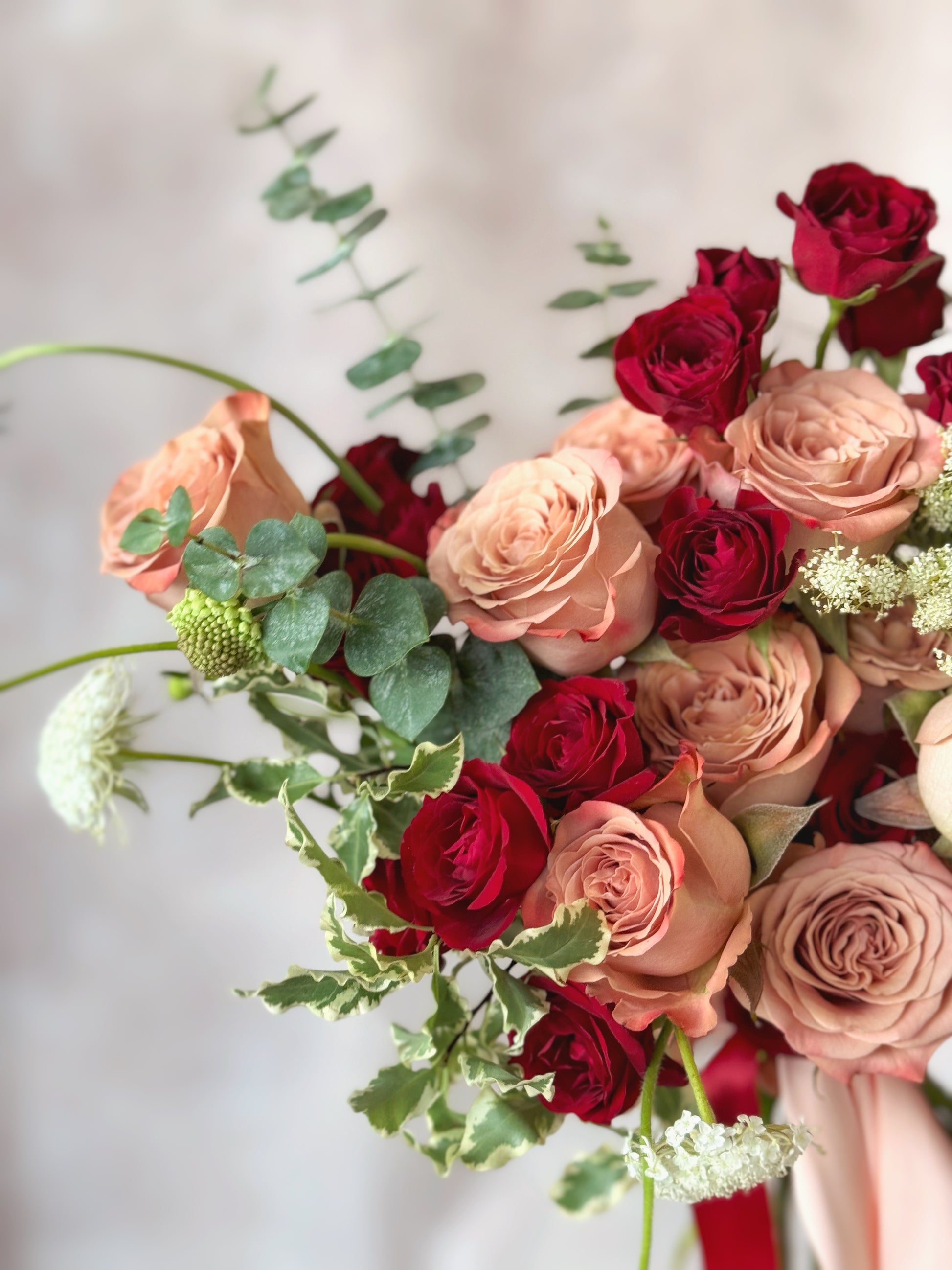Amelia fresh flowers fan shaped bridal bouquet grand size close view, a refined floral arrangement featuring red spray roses, cappuccino roses, and a blend of warm-toned blooms for a timeless wedding bouquet.