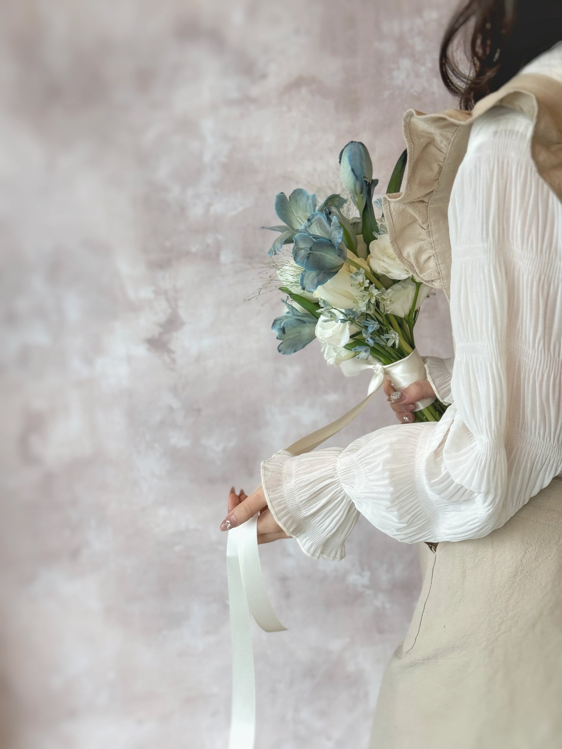 The soft hues of dusty blue blooms beautifully complement the bride’s ethereal look
灰蓝色花朵的柔和色调,完美衬托新娘的仙气造型