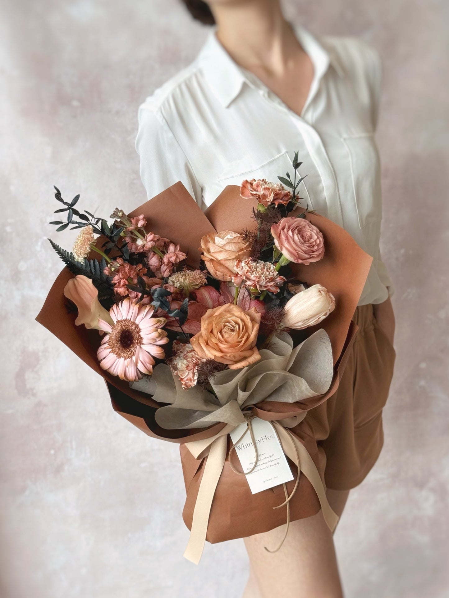 Stylish brown theme stem dyed mix fresh flowers bouquet. A model holding the modern spray-painted bouquet, capturing the bold colors and unique design.
手持现代喷染花束的生活照,展现大胆色彩与独特设计。
