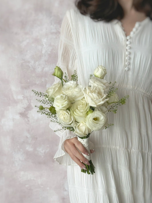 Model holding a classic Korean-style white bridal bouquet, featuring fresh roses and eustoma flowers for a soft and romantic touch
新娘手持经典韩式纯白捧花,增添优雅永恒的气质