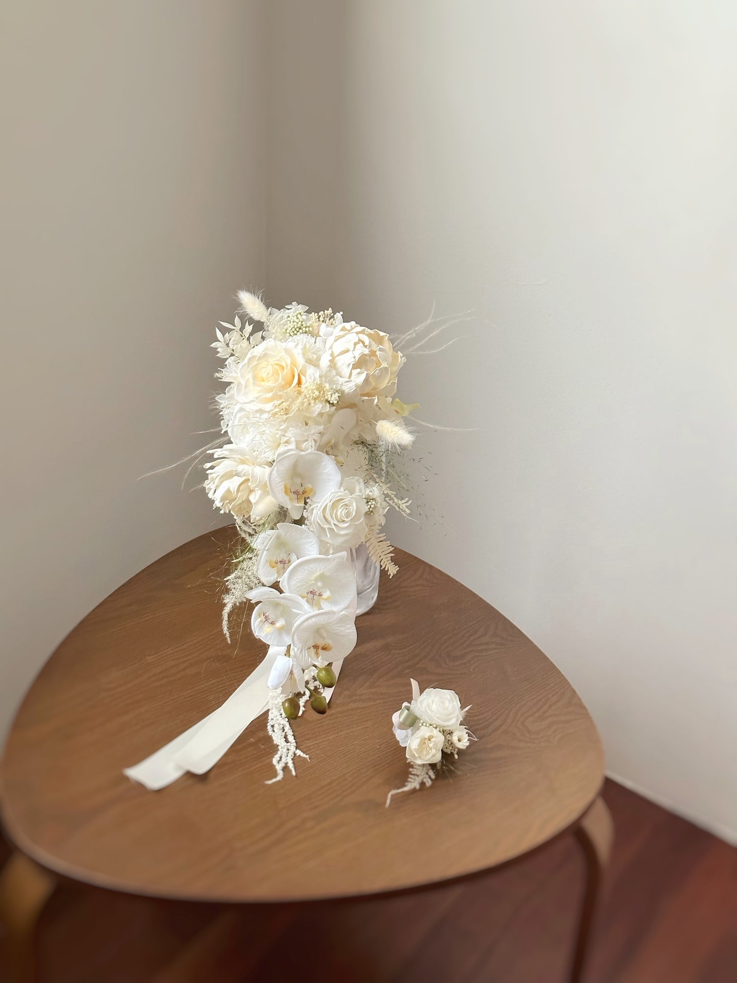 Preserved flowers bouquet with a matching preserved flowers boutonniere for the groom. A beautifully coordinated corsage set featuring preserved white florals and pastel accents, mirroring the elegance of the bridal bouquet.
与新娘捧花相呼应的优雅永生花胸花套组,采用纯白花材与柔和粉色调,尽显和谐美感。