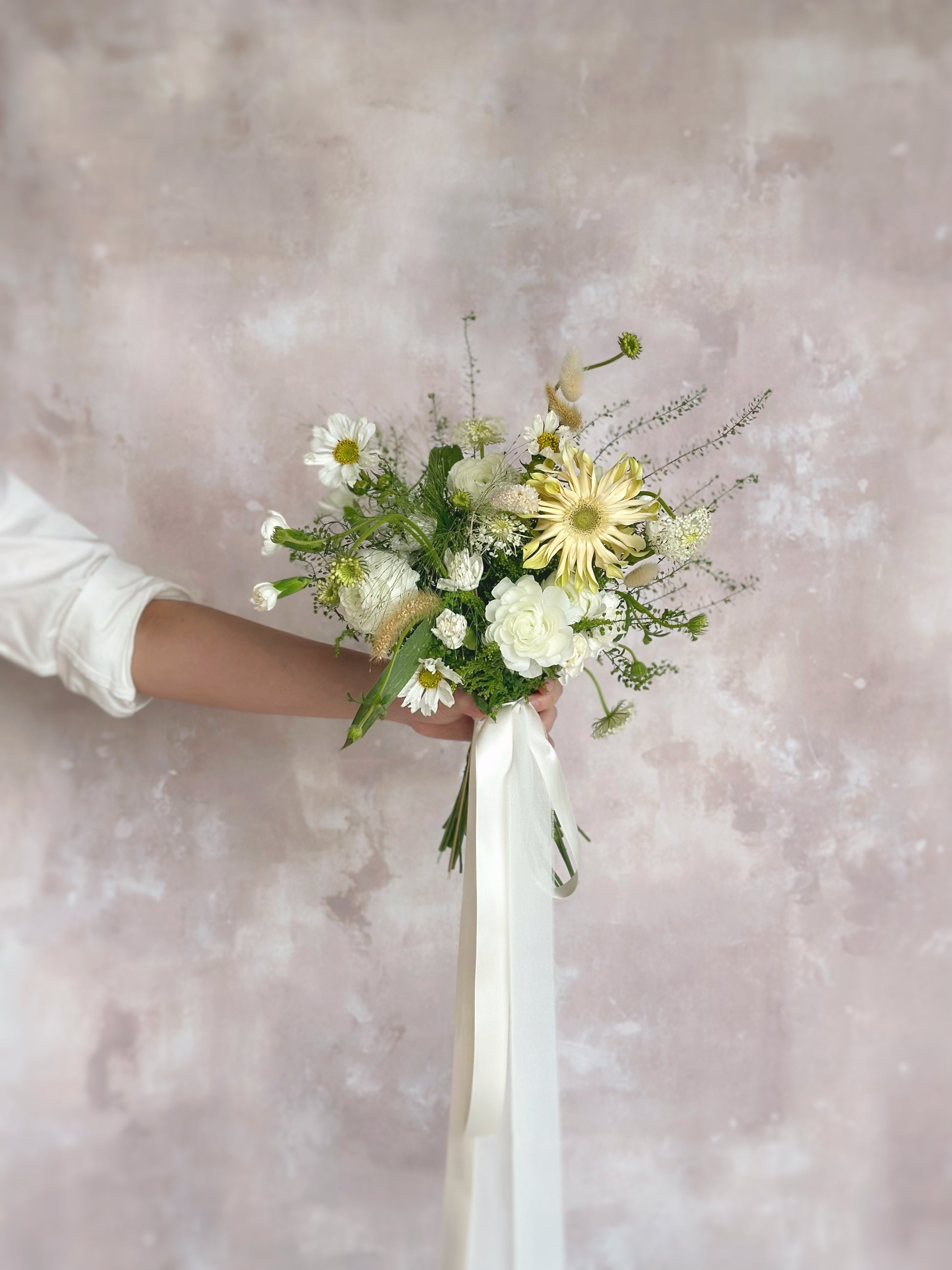 A lush, freeform bridal bouquet with creamy blooms and abundant greenery
森系自然随性的茂盛新娘捧花,搭配奶油色混搭花朵与丰富绿植