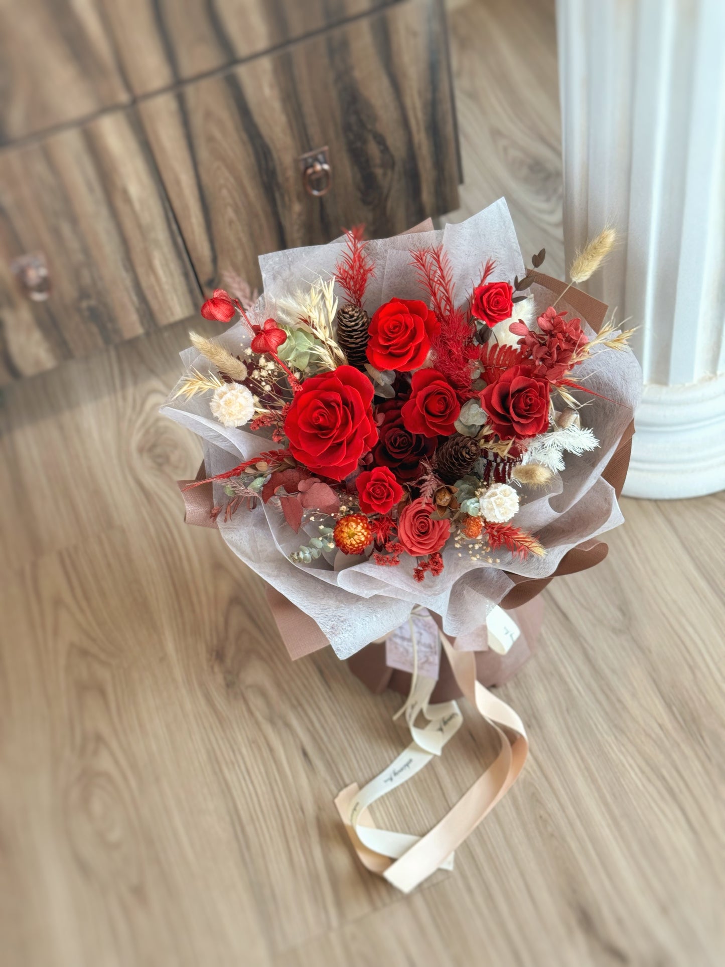 The Crimson Dusk bouquet placed on a table, allowing a full view of its rich, earthy tones and dramatic, timeless beauty.
“Crimson Dusk”花束放置在桌上,展示其丰富的土色调和戏剧性的永恒美感。