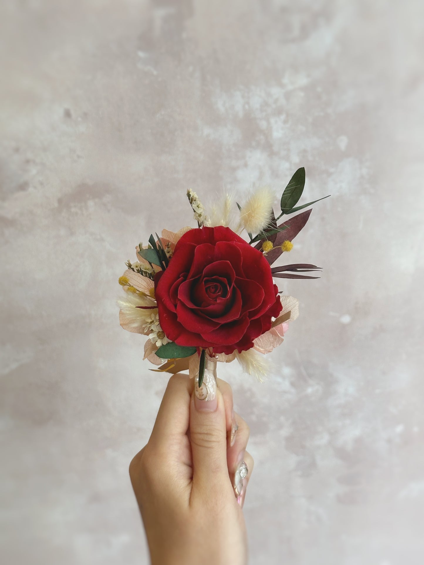 Hand holding a preserved corsage, perfect for an oriental wedding with elegant and traditional charm