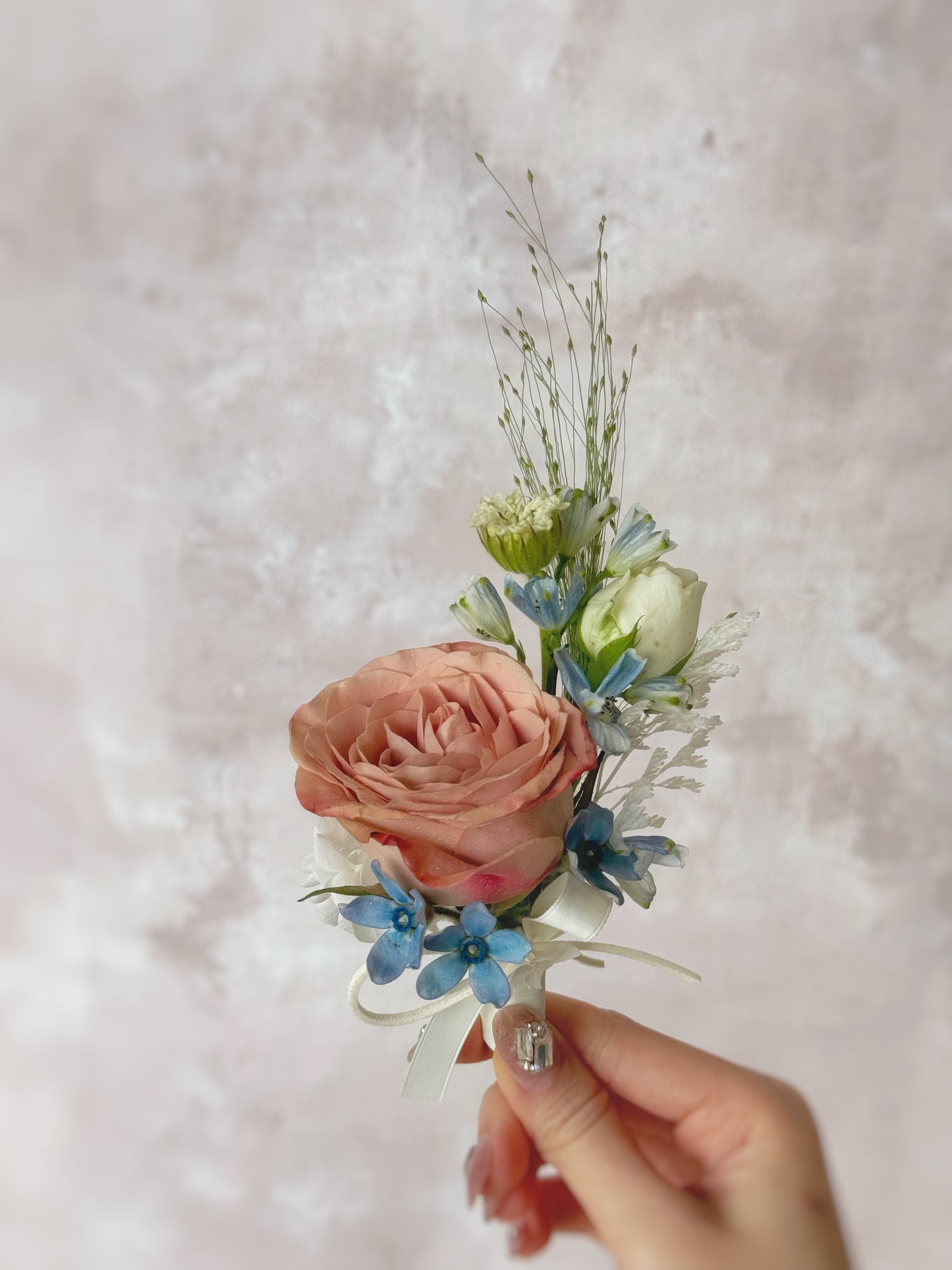 Corsage with cappuccino rose with blue fillers and foliage