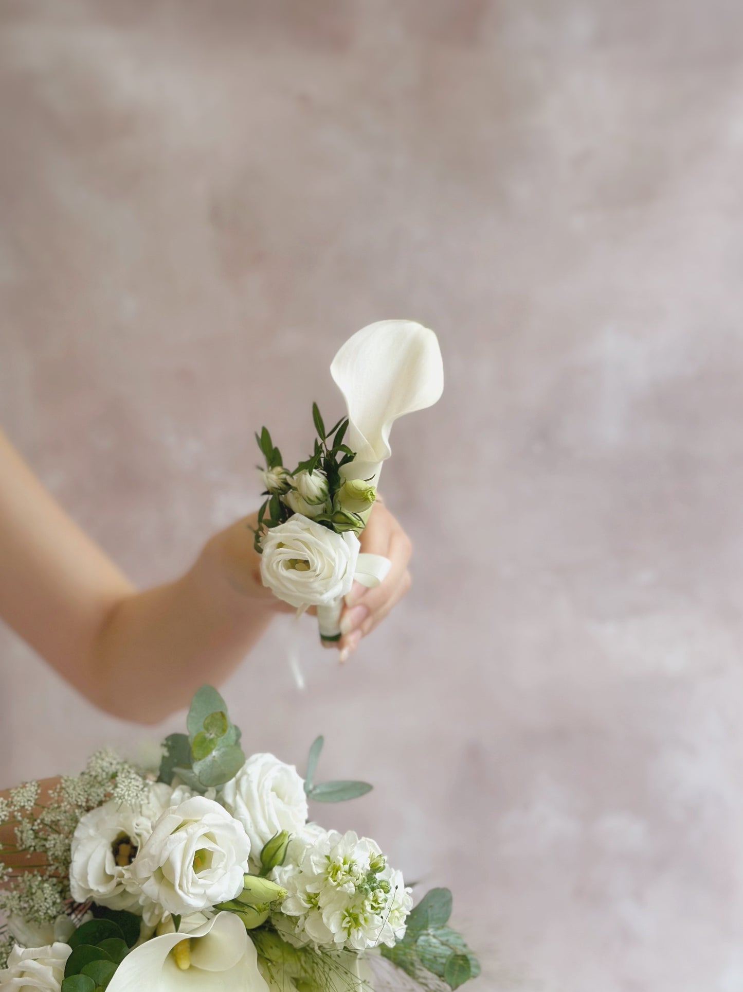delicate touch white calla lily corsage holding by a model