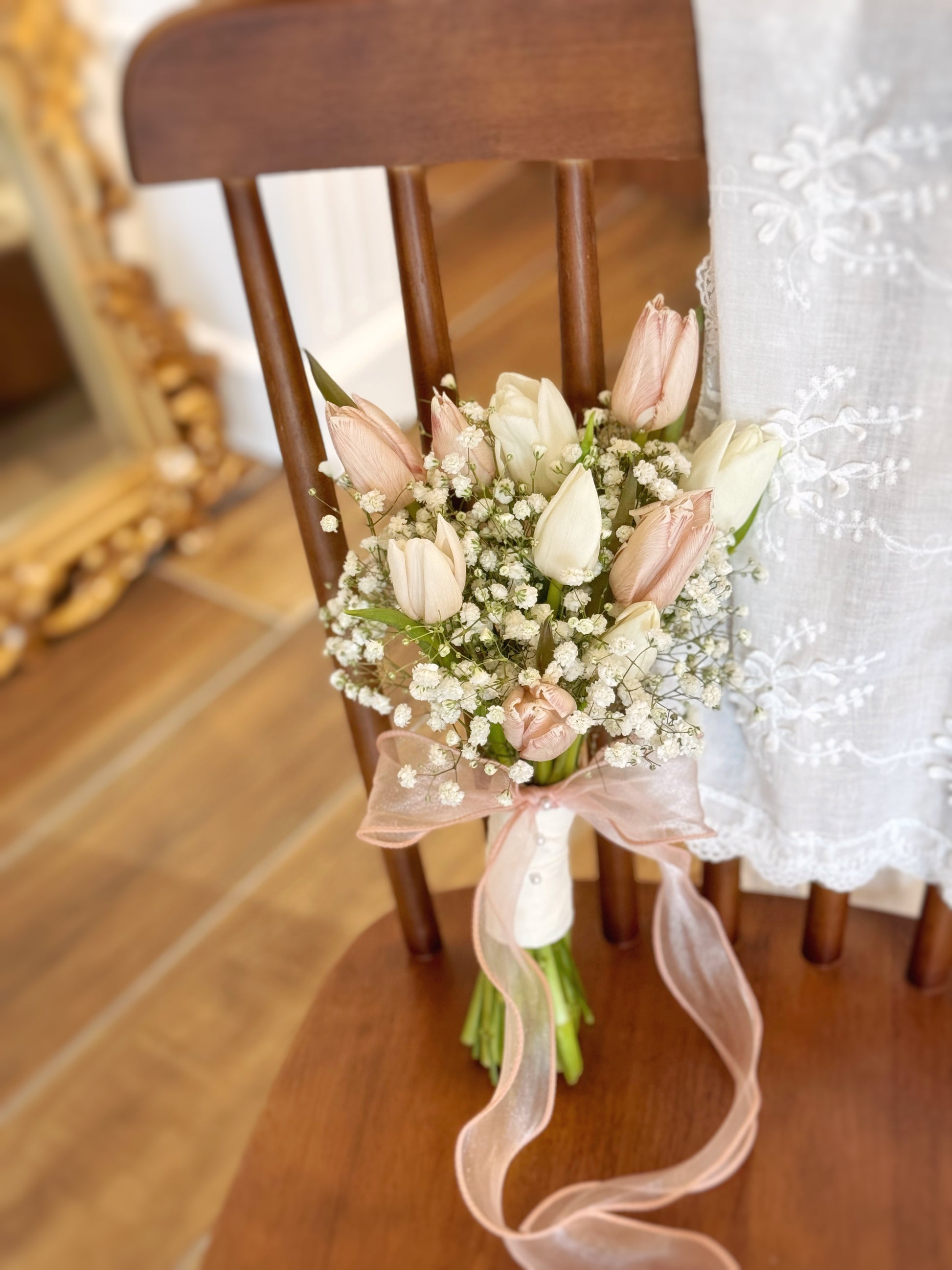 Close-up of tulip petals in soft white and warm brown hues, with delicate baby’s breath nestled between blooms.
特写镜头呈现郁金香柔和白色与暖棕色花瓣,点缀轻柔满天星。