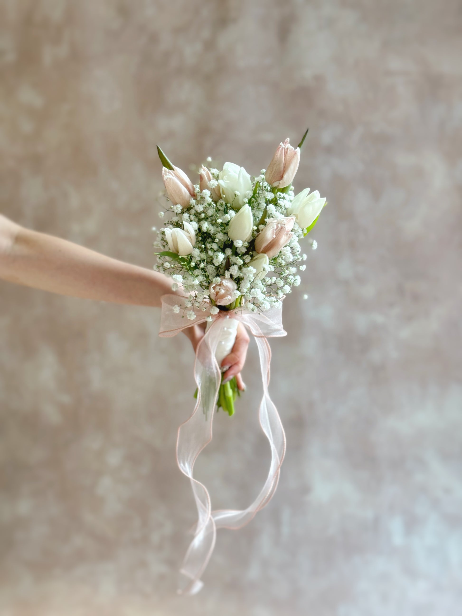 Bouquet held at arm’s length, showcasing the tulips’ soft beauty and delicate textures.
仅展示手臂与手部延伸握花画面,突显郁金香的柔美细节与温柔气质。