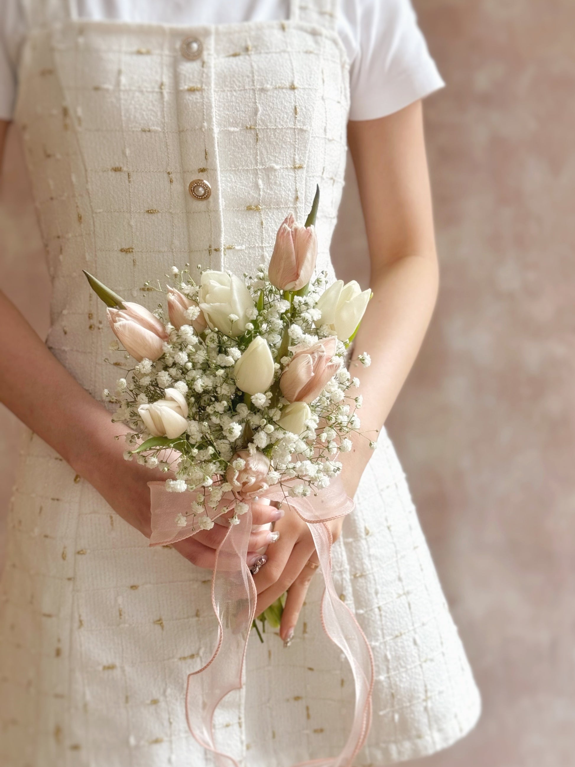 Bouquet held in hand by a model in a bridal setting, conveying an aura of softness, natural beauty, and quiet elegance.
: 模特手持花束,传递自然柔美与静谧高雅的氛围。