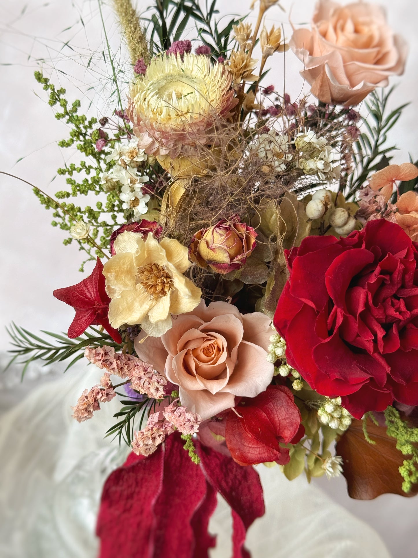 A detailed look at the preserved roses, orchids, and foliage, highlighting the rich maroon tones with subtle hints of purple and green.
特写镜头捕捉永生玫瑰、兰花与叶材的细腻质感,深酒红色调中点缀淡紫与绿色。