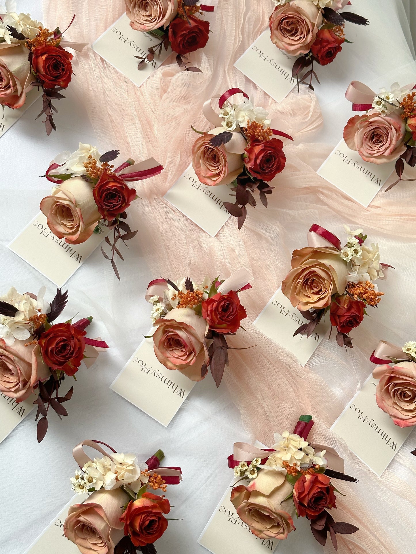 Top view of multiple Faye fresh cappuccino rose corsage in bulk for wedding reception