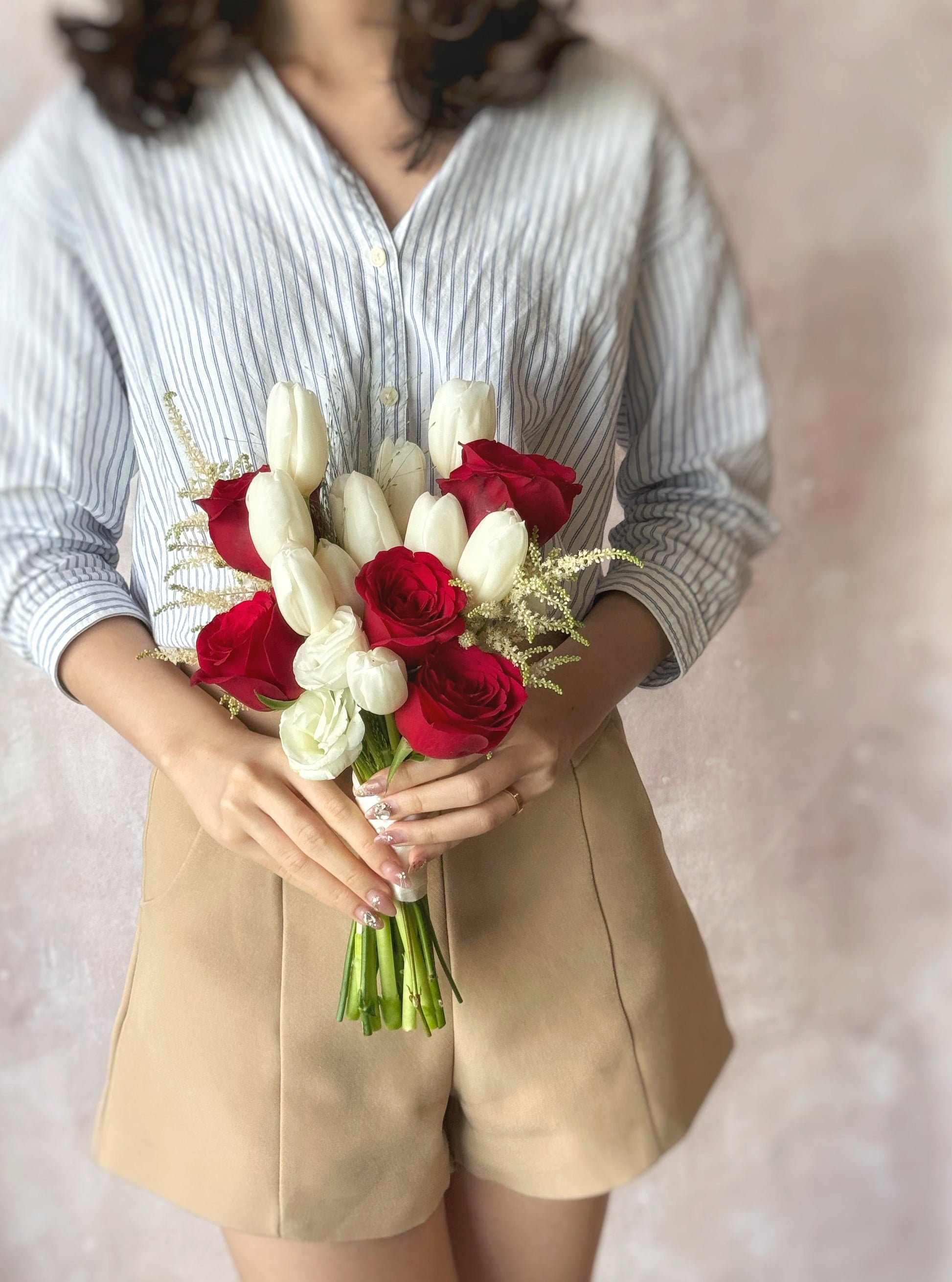 A model holding an elegant red and white tulip bouquet, a timeless choice for weddings
新娘手持优雅红白郁金香捧花,永不过时的婚礼选择