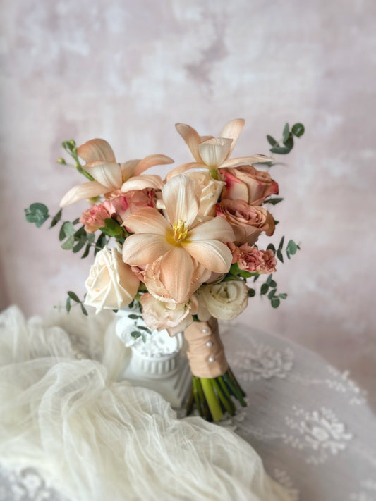 Florette fresh flowers bridal bouquet, a romantic muted-tone bridal bouquet featuring cappuccino roses, soft pastel blooms, and earthy light brown tulips, elegantly arranged on a table
低饱和色调的新娘捧花,融合卡布奇诺玫瑰、柔和粉彩花朵与橄榄绿点缀,呈现自然浪漫气息