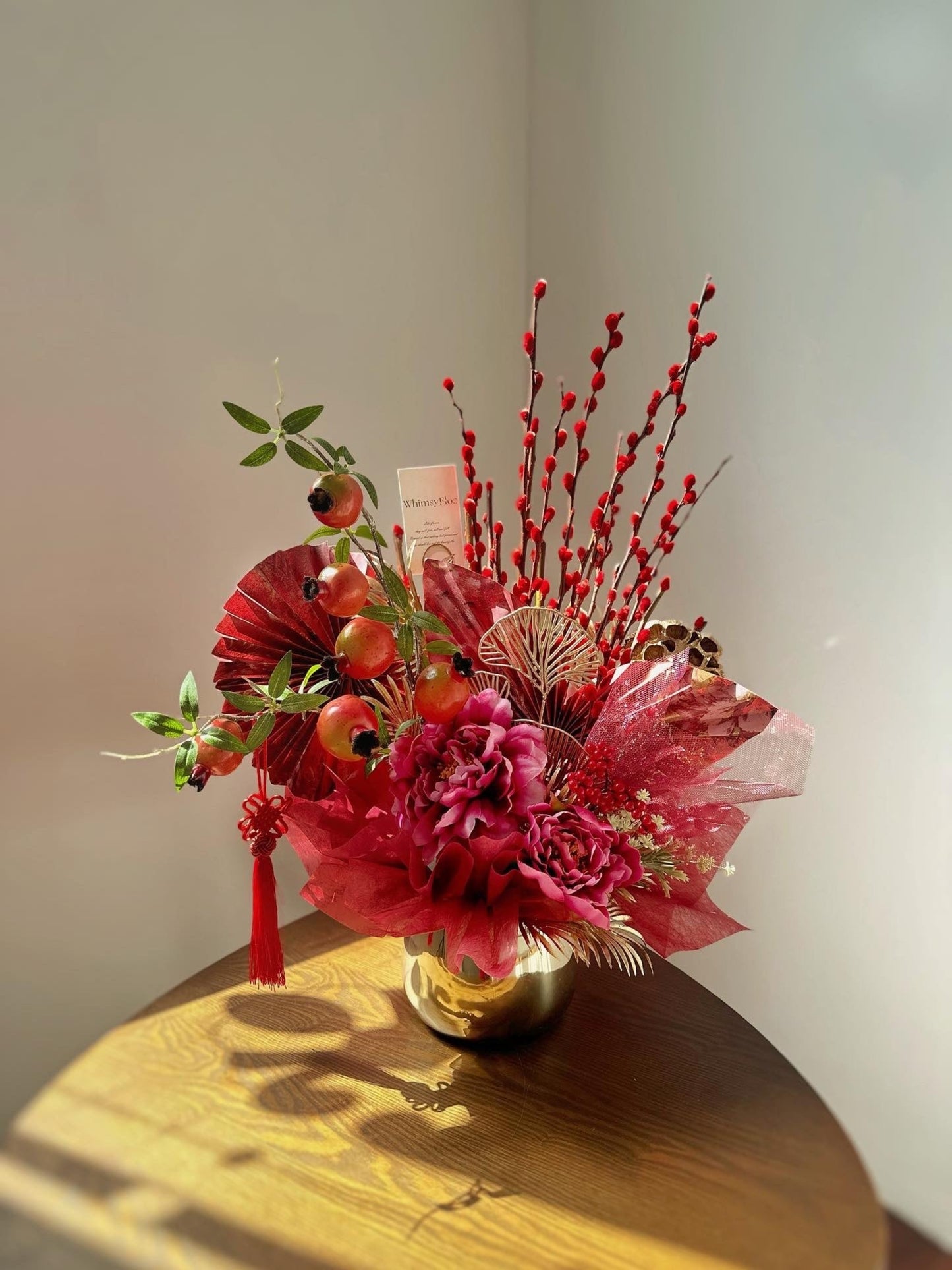 Chinese new year vase arrangement design with faux peony flower, pomegranate, pussy willow, lotus and assorted fillers.