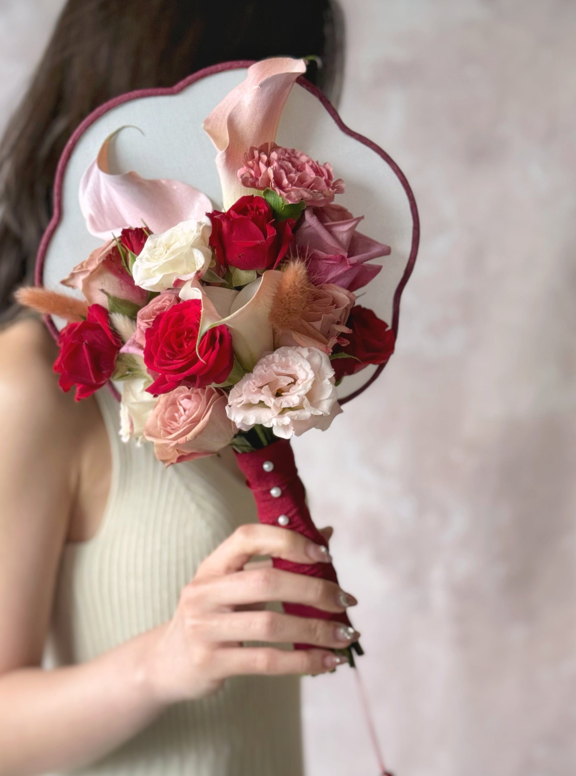 Bride holding a floral bridal fan bouquet, symbolizing tradition and grace with a modern twist
新娘手持鲜花扇花束,象征传统与优雅,并融入现代设计感