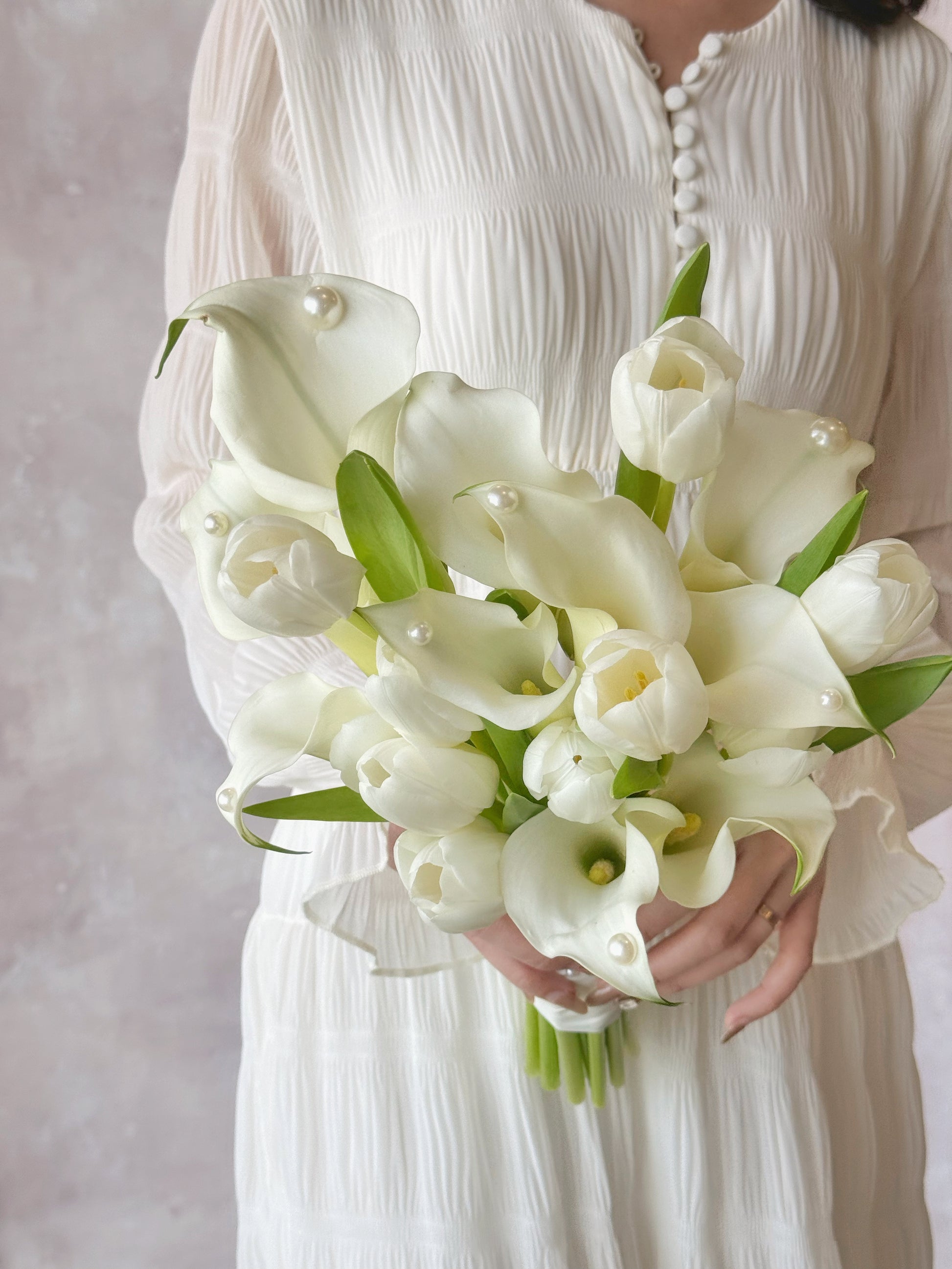 Genuine fresh flowers bridal bouquet calla lily top view, a soft-focus detailed shot of calla lilies and tulips in a wedding bouquet, emphasizing their sleek and graceful appearance 时尚现代的马蹄莲与郁金香新娘捧花,适合现代婚礼风格