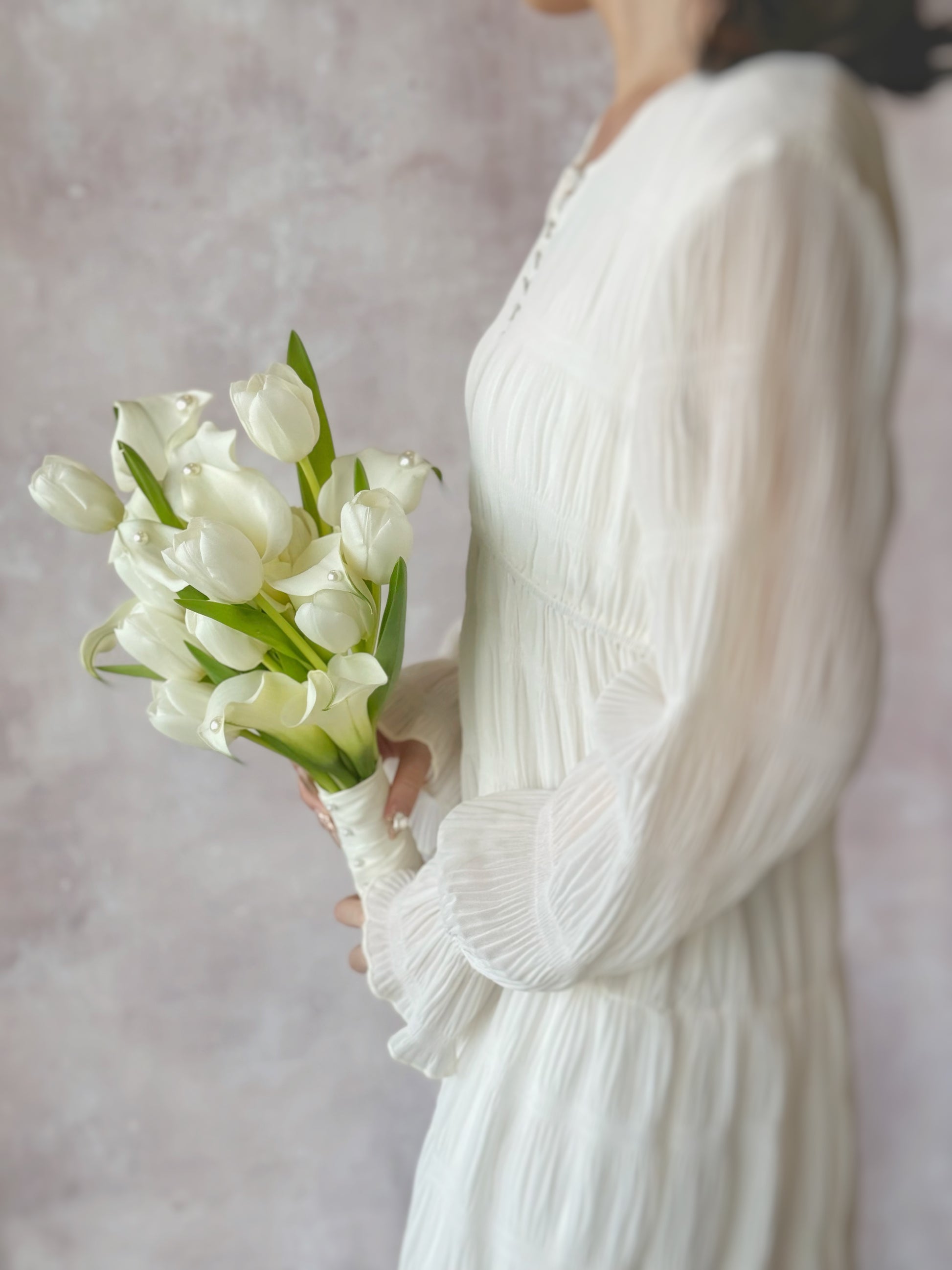 Genuine fresh flowers bridal bouquet calla lily side view, an elegant floral details of a calla lily and tulip bouquet, ideal for minimalist brides seeking a modern yet romantic touch
韩式极简新娘捧花细节,突出马蹄莲与郁金香的光滑花瓣与优美线条