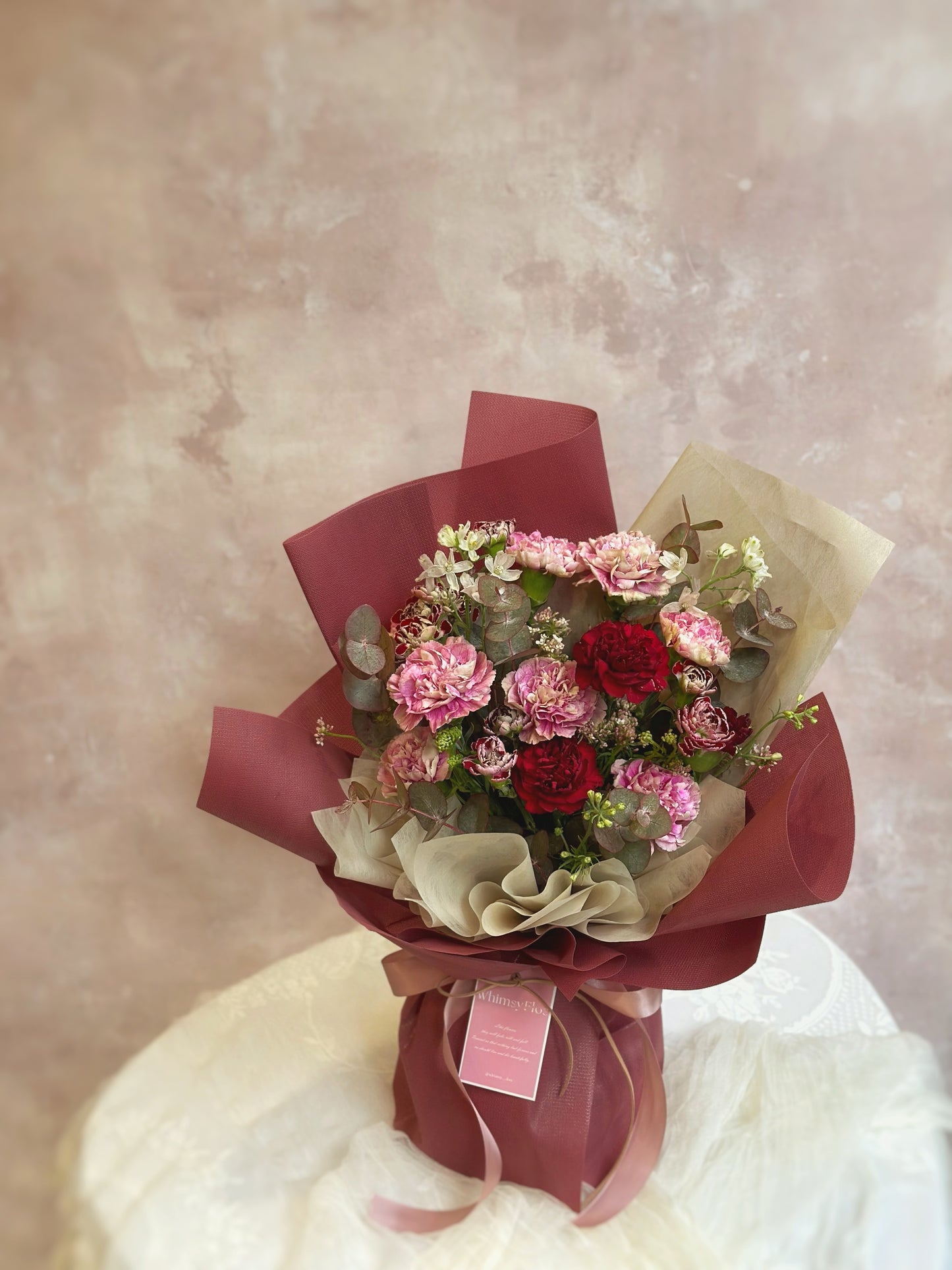 This bouquet features an array of delicate carnations in soft, vintage-inspired hues