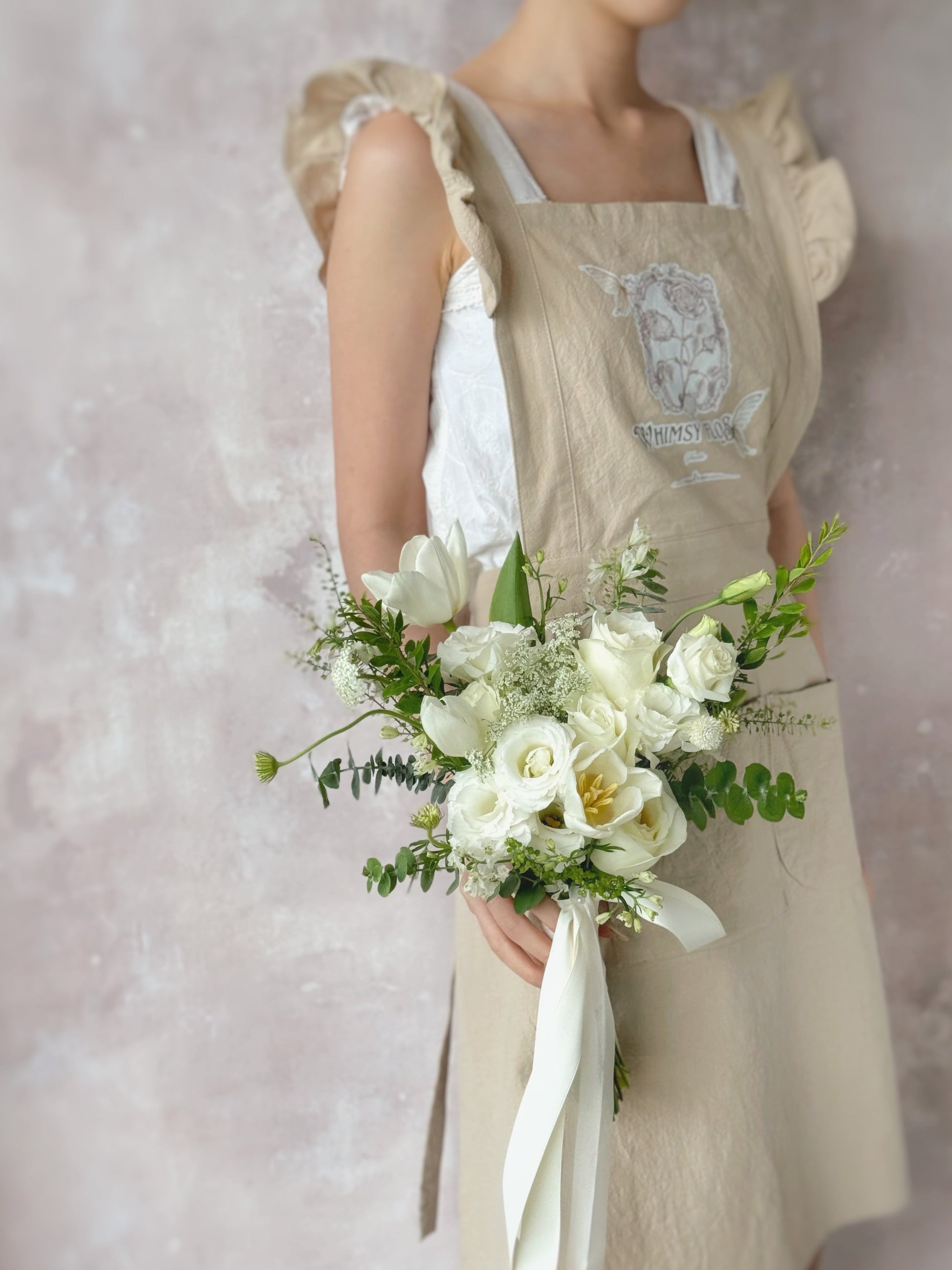 新娘手持浪漫清新的白色捧花,散发迷人纯净气息