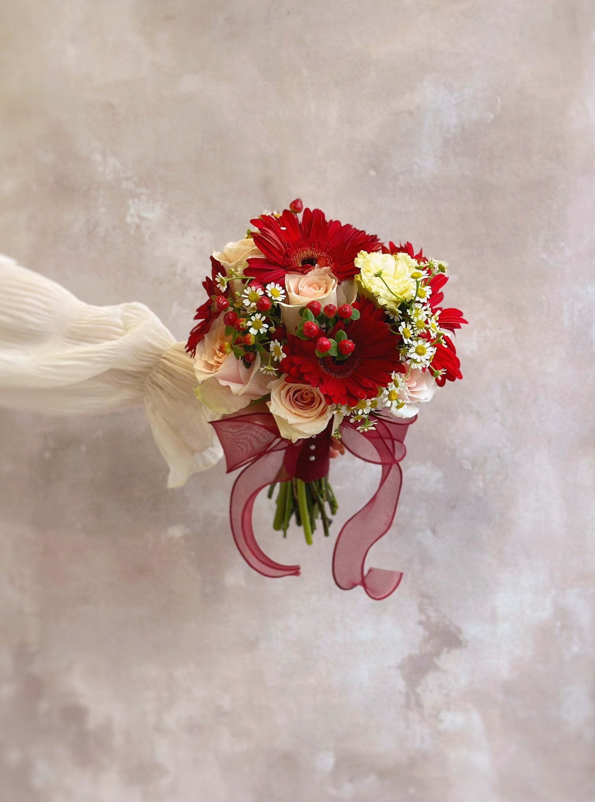 The perfect mix of gerbera, chamomile, and peach roses for a bright bridal look
洋甘菊、雏菊与桃色玫瑰的完美组合,打造明亮新娘造型