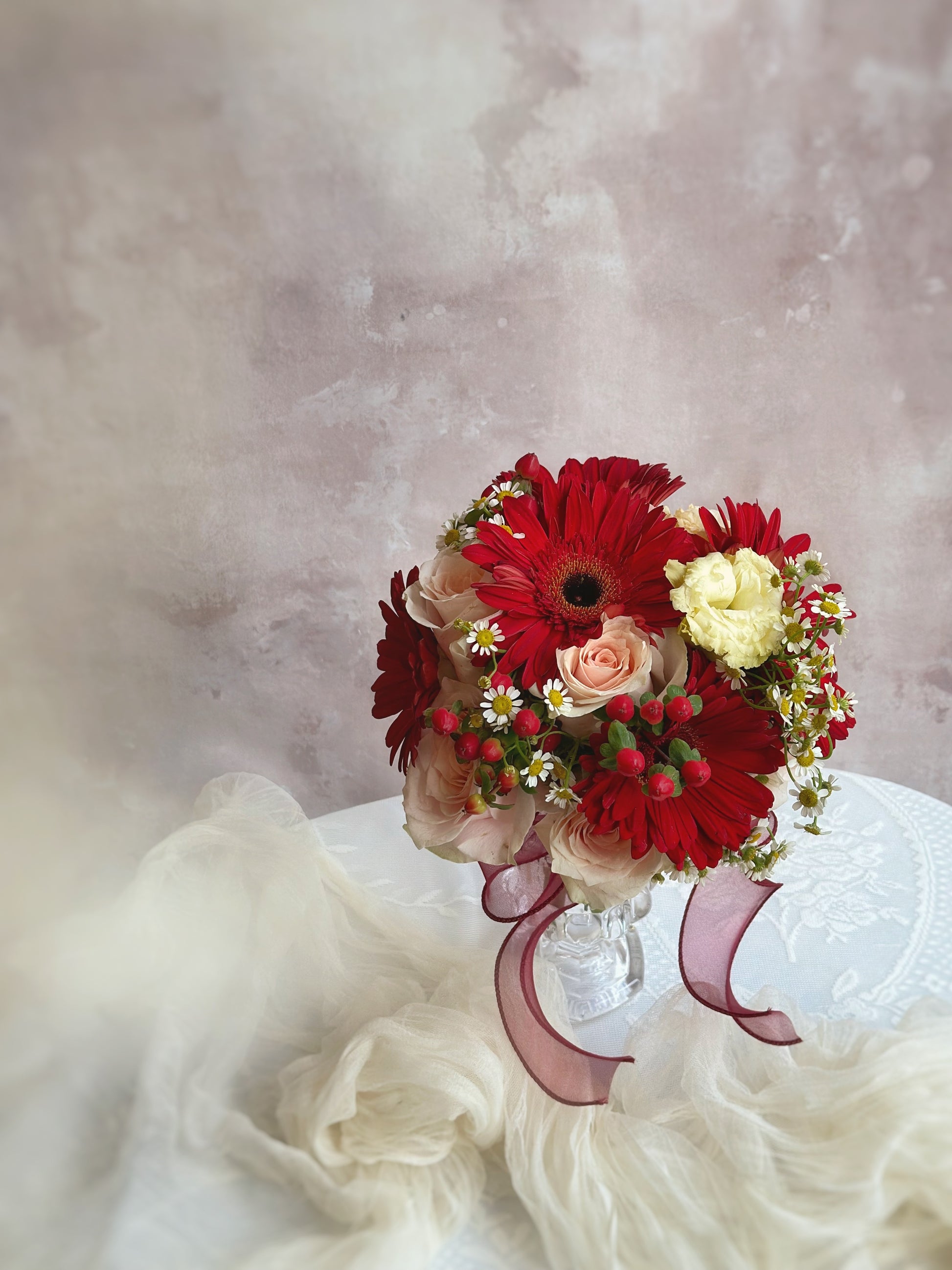 Soft gerbera petals surrounded by chamomile and roses for a rustic touch
柔美的洋甘菊花瓣环绕着桃色玫瑰,展现田园风情