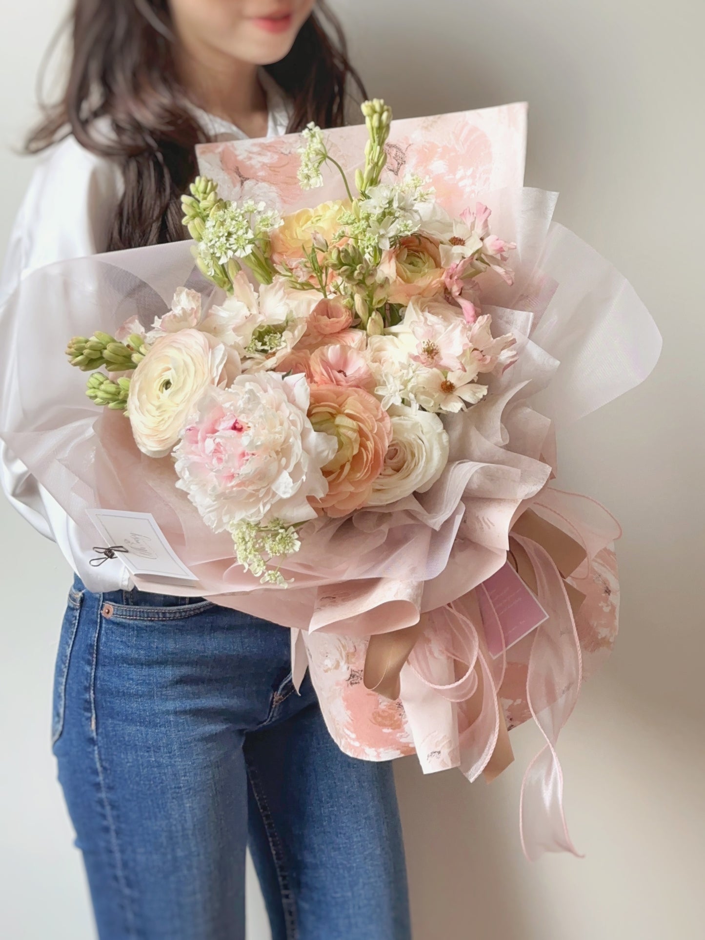 Front view of a blush pink bouquet wrapped in matching art paper and sheer ribbon, showcasing a soft and romantic design.
正面展示柔粉色系花束,搭配同色调艺术纸与薄纱丝带,整体设计柔美浪漫。