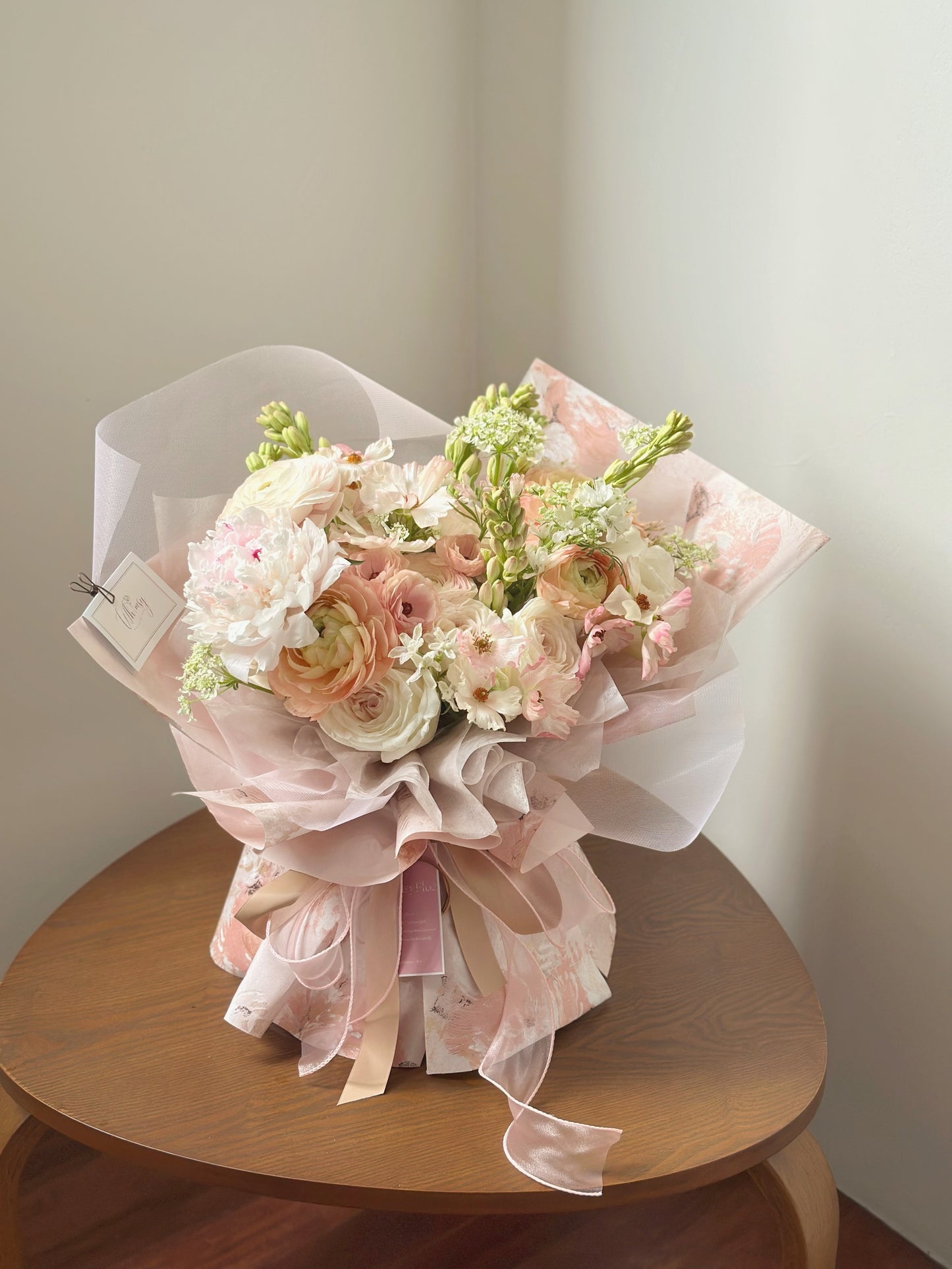 Top-down view of the bouquet showing its rounded form and carefully layered blush blooms.
俯拍视角展现花束的圆润造型与层叠排列的粉色花朵。