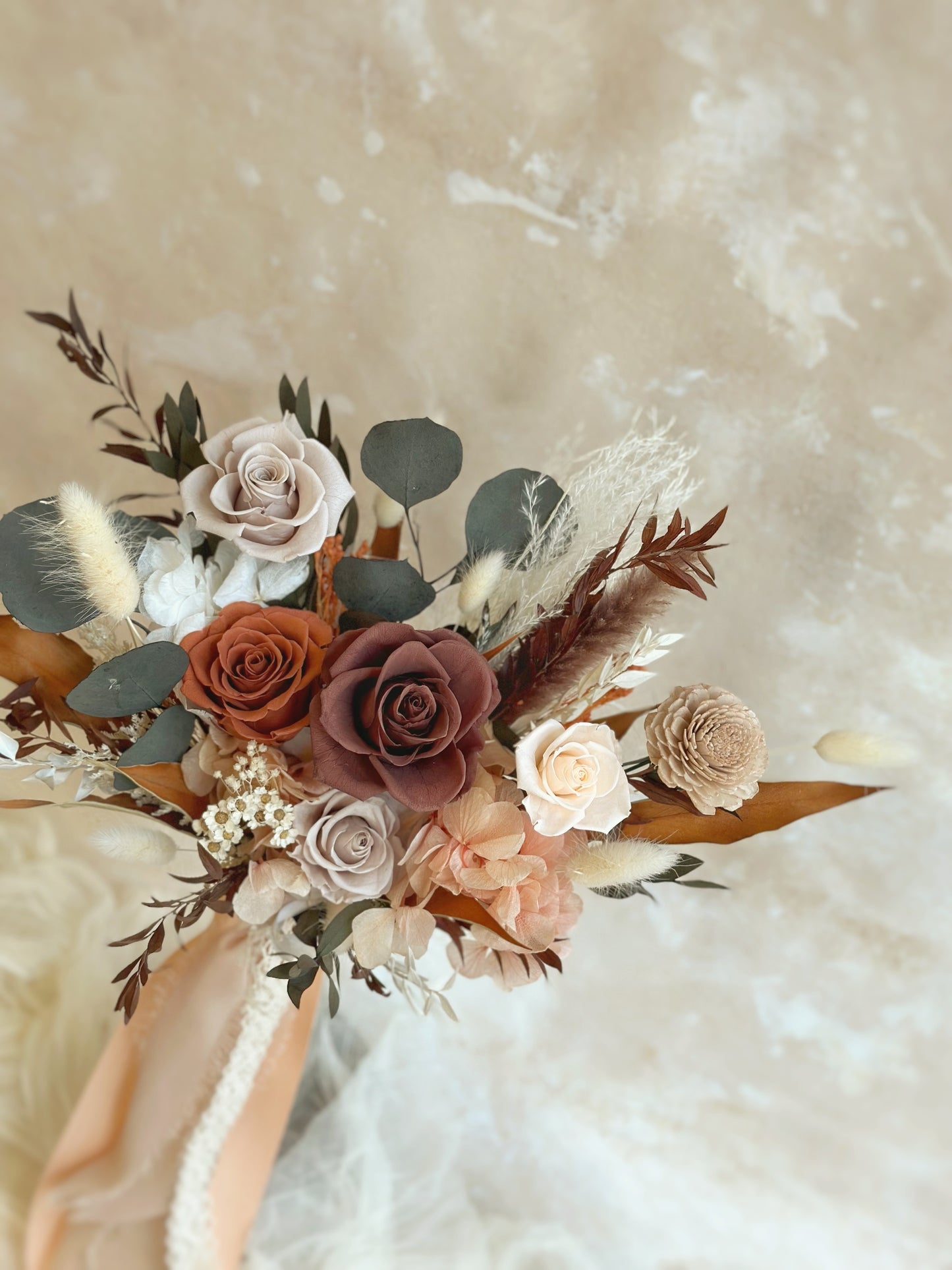 A close-up of the terracotta, burnt orange, and warm beige preserved flowers, showcasing rich hues and textures.
赤陶色、焦橙色与暖米色永生花的特写,展现浓郁色彩与丰富层次。