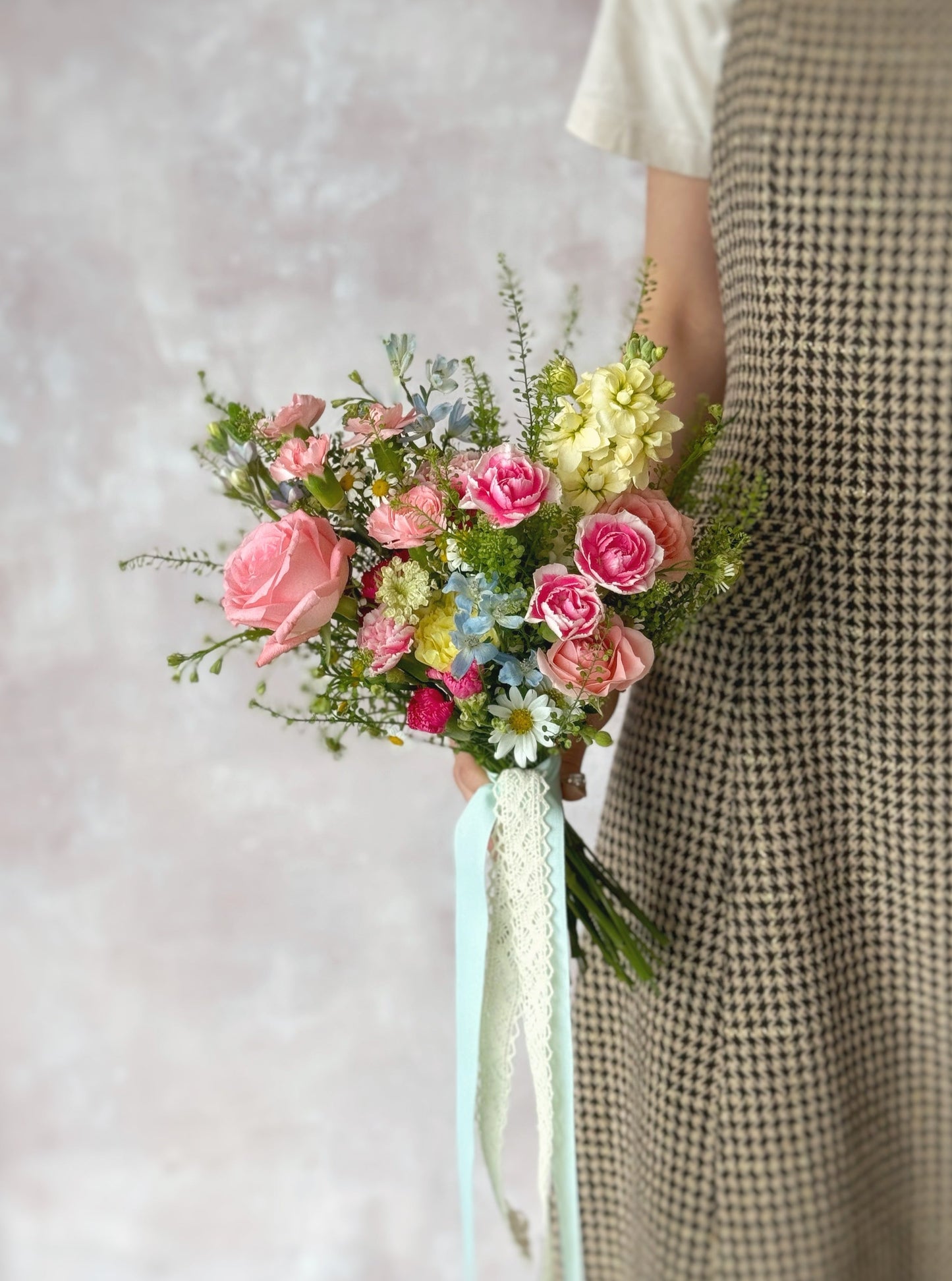 Le jardin fresh flowers bridal bouquet front view luxe size held by model at the side, a bright and lush French garden-style bouquet, overflowing with colorful blooms for a radiant wedding look
新娘手持充满生机的法式花园风捧花,为幸福婚礼增添亮点