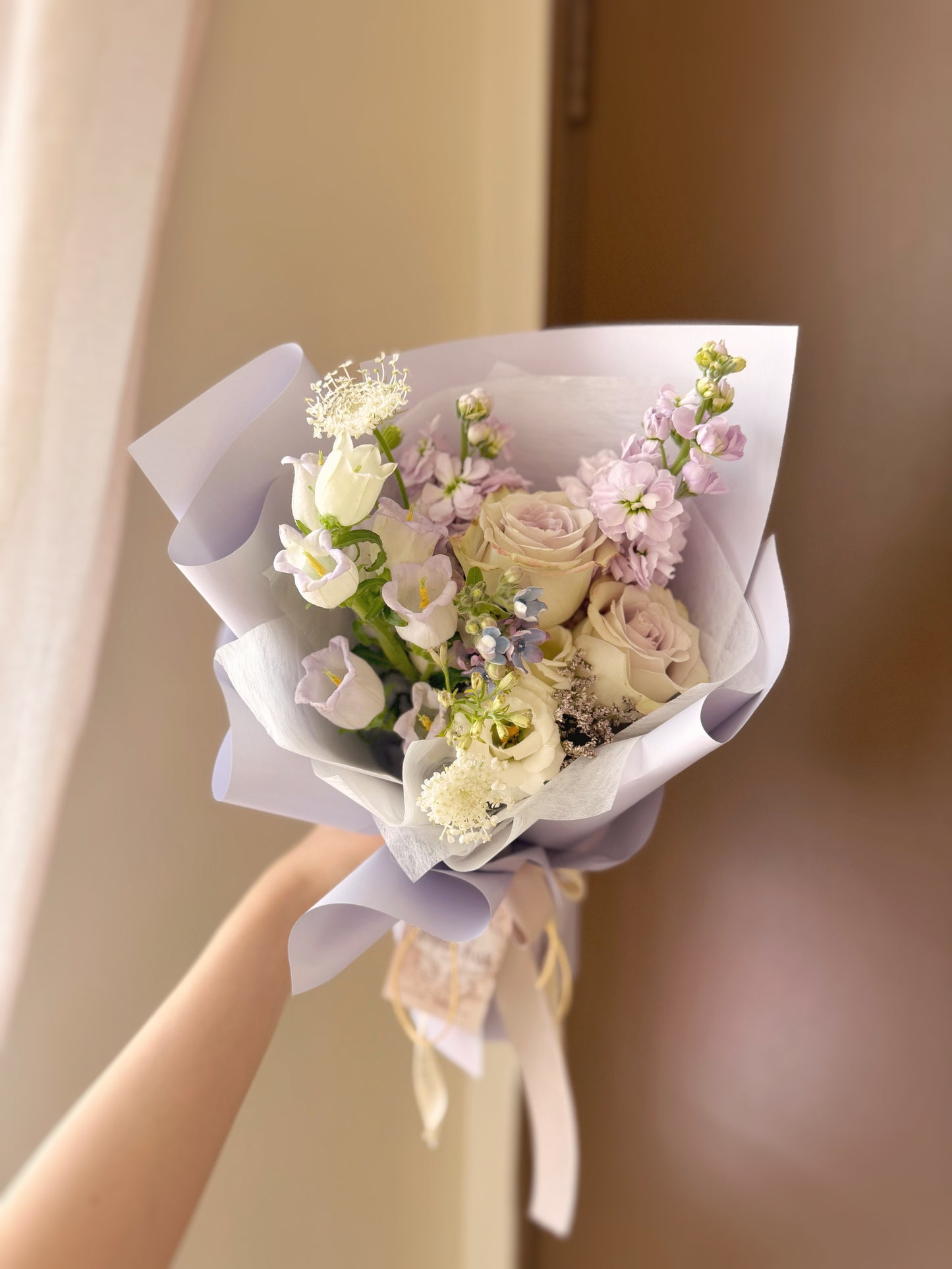 adorable size lilac tone fresh flowers bouquet held in hand