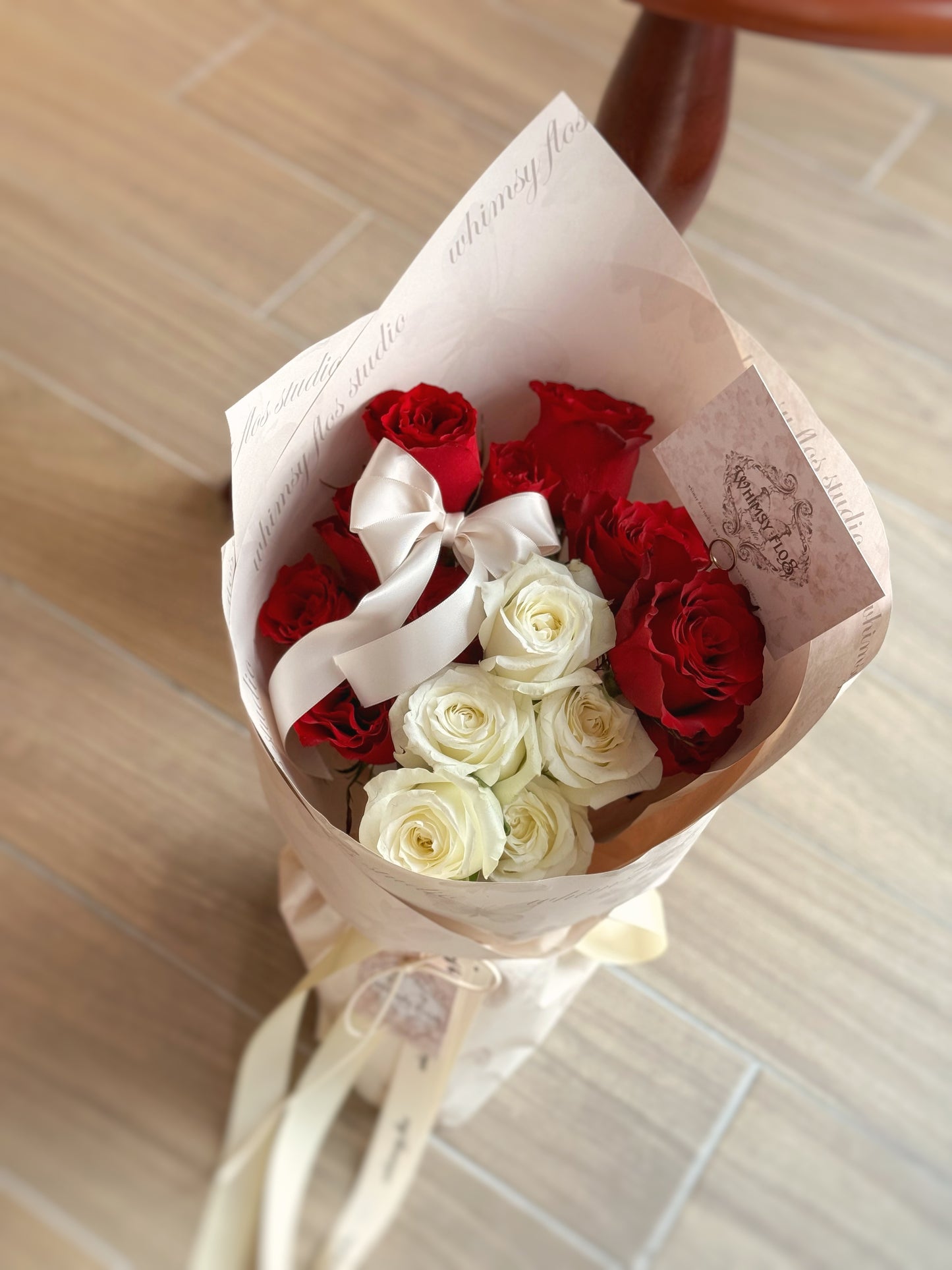 Close-up view of Luna Kiss bouquet, featuring deep red and pure white fresh roses wrapped in minimalist style with silky ribbons for a refined, elegant look.