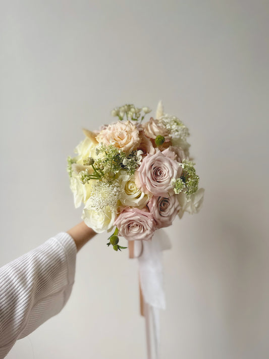 Close-up shot of the pastel rose bridal bouquet, showing delicate textures and subtle variations in the menta and quicksand rose shades.
近距离拍摄的新娘捧花,展现柔和的曼塔玫瑰和流沙玫瑰花瓣质感和细腻的色彩变化。