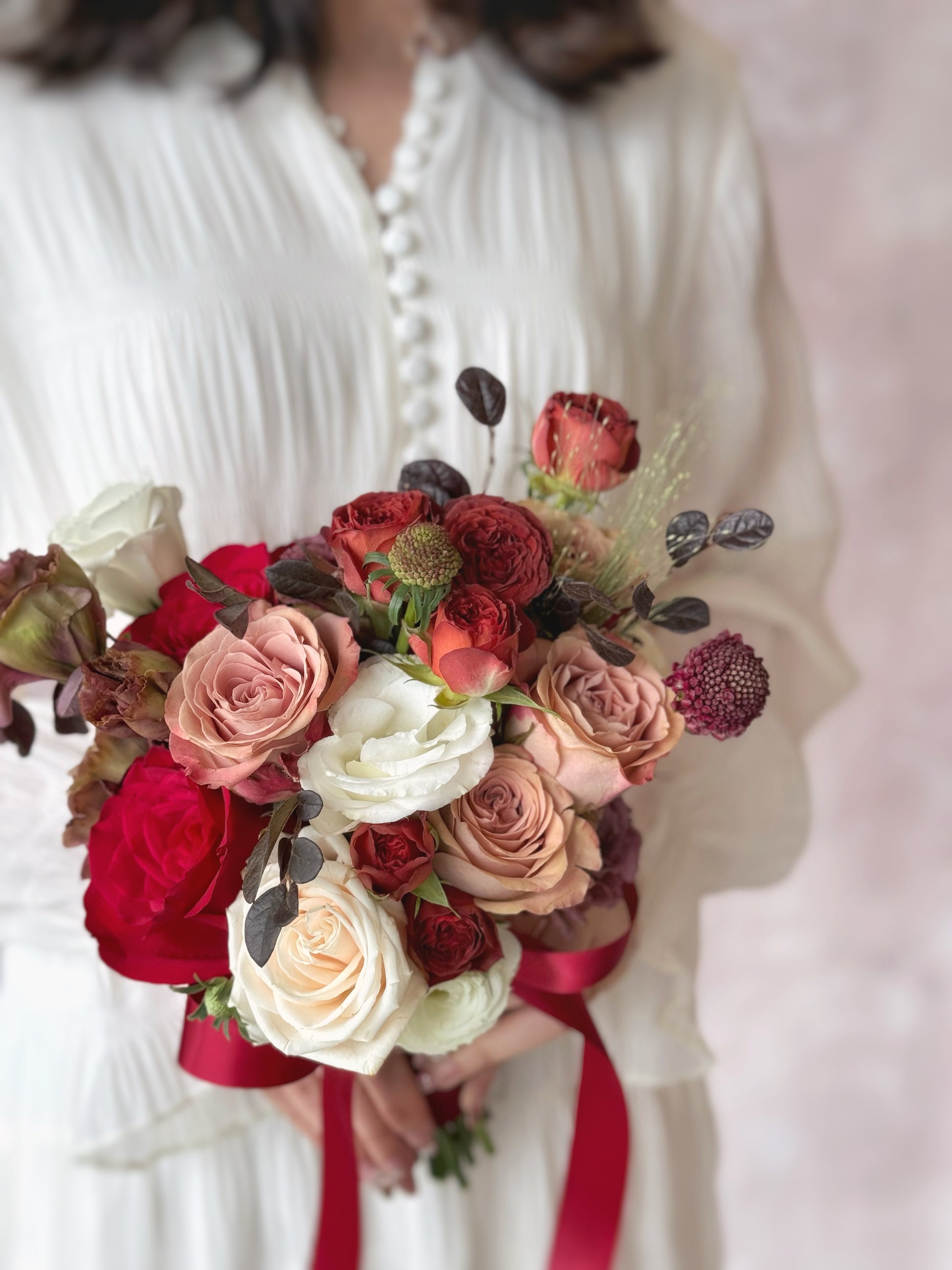 Detailed view of a fresh flower bouquet with a striking contrast of deep mauve and maroon against delicate white and dusty blush flowers.
浪漫又不拘一格的新娘捧花,适合追求独特艺术感的婚礼造型