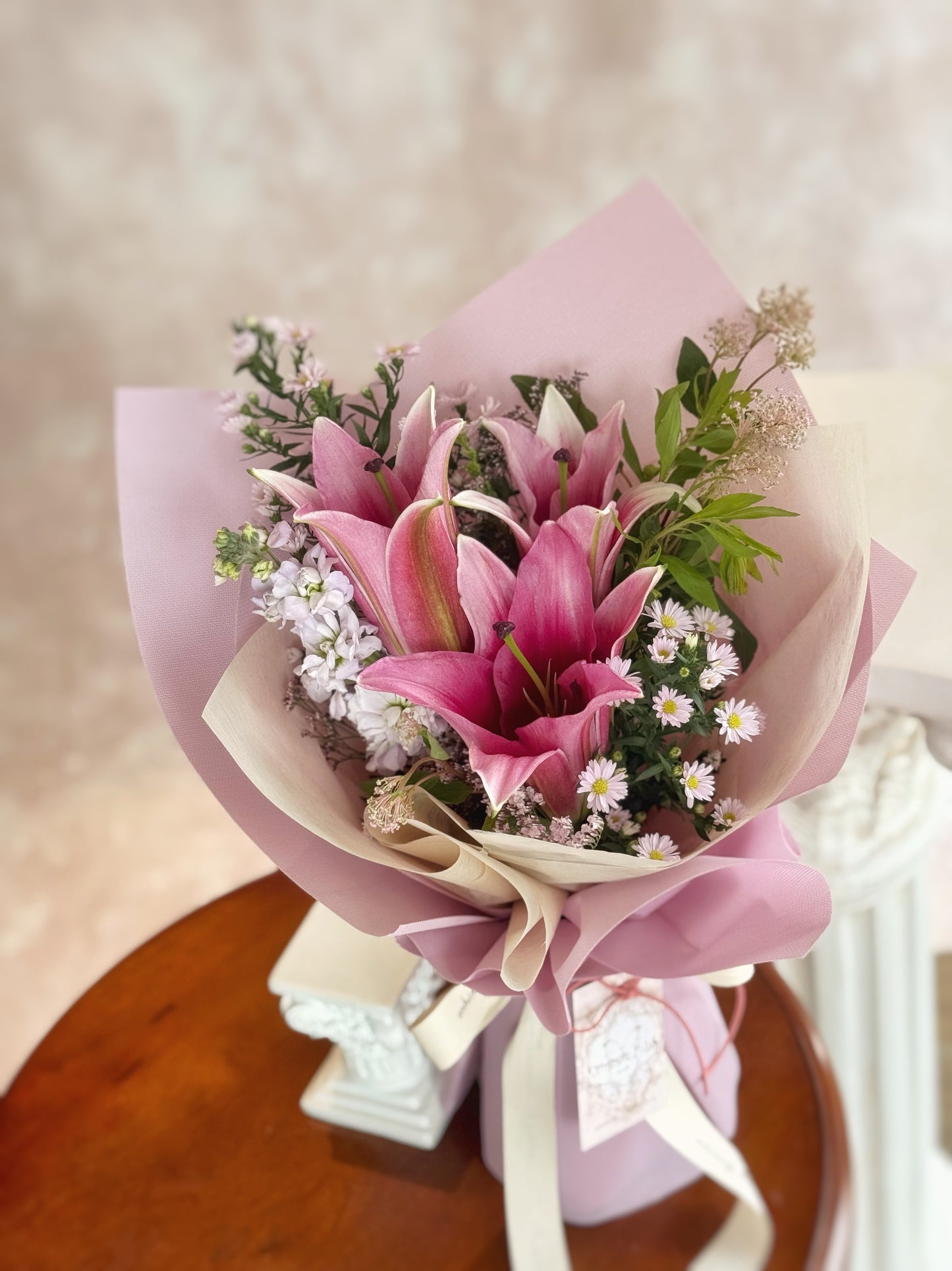 Fresh pink lilies bouquet arranged on a table, adding a bright yet tender touch to the surrounding space.
百合花束摆放在桌面,增添空间中明亮而柔美的氛围