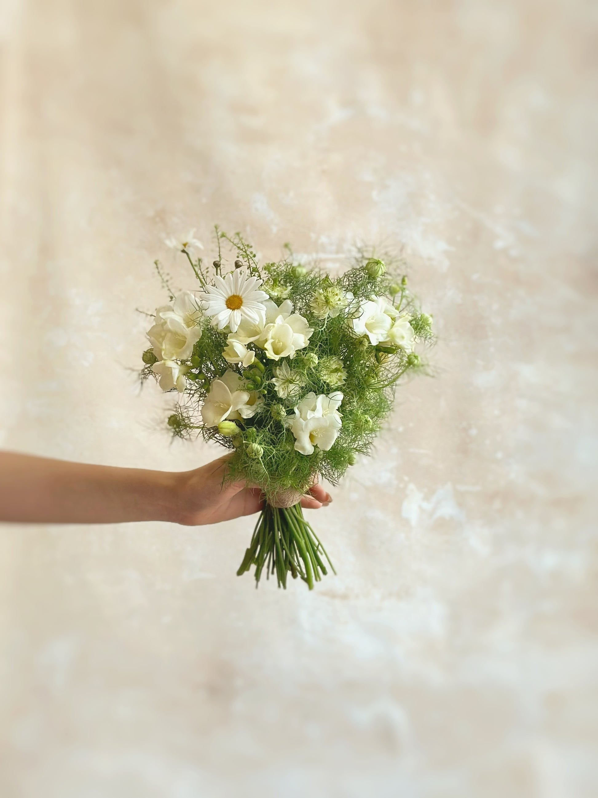 Zooming in on the bouquet’s details, the fluffy ivory blooms and fresh greenery create a delicate and airy floral arrangement, perfect for a nature-inspired bride.
象牙色花朵轻盈蓬松,搭配清新绿叶,打造精致透气的花束,非常适合钟爱自然风格的新娘