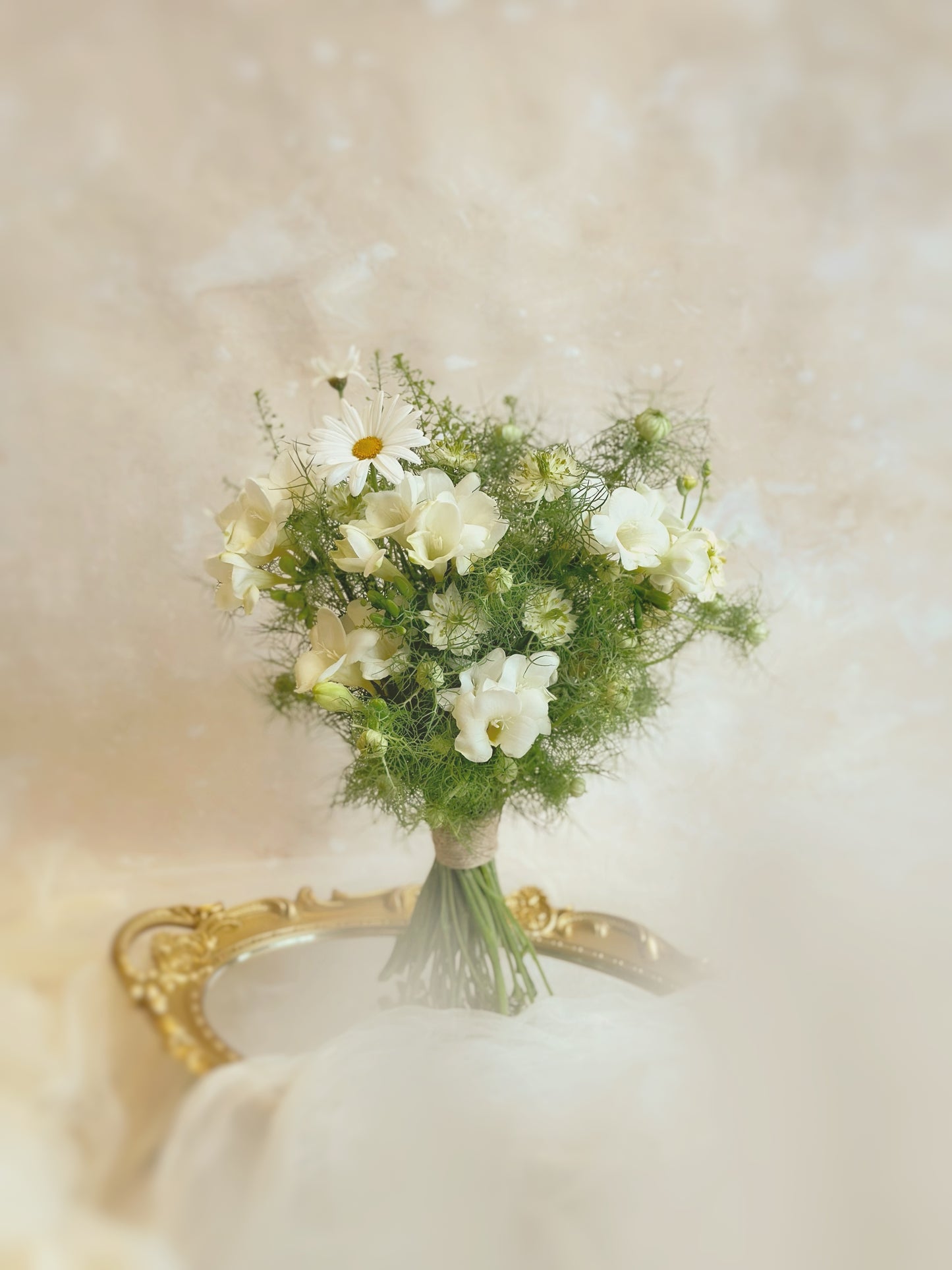 A delicate ivory wildflower bouquet with lush greenery, beautifully arranged on a table. The natural textures and soft colors create a fairy-like garden aesthetic, perfect for weddings or photoshoots.
柔和的象牙色野花捧花搭配茂密绿叶,精致地摆放在桌面上,呈现出梦幻花园风格,非常适合婚礼或拍摄。