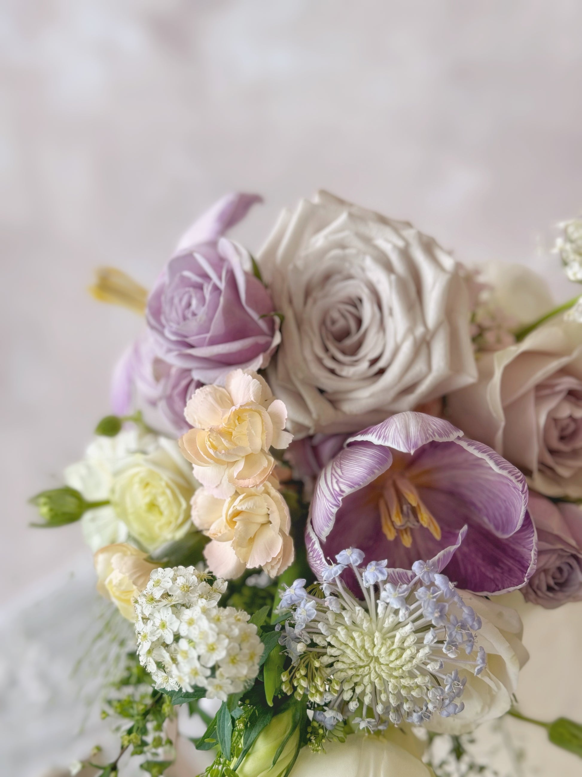 A beautifully arranged teardrop bridal bouquet featuring cascading Phalaenopsis orchids in a dreamy lilac and white palette
充满梦幻感的紫丁香与白色瀑布型新娘捧花,点缀优雅蝴蝶兰
