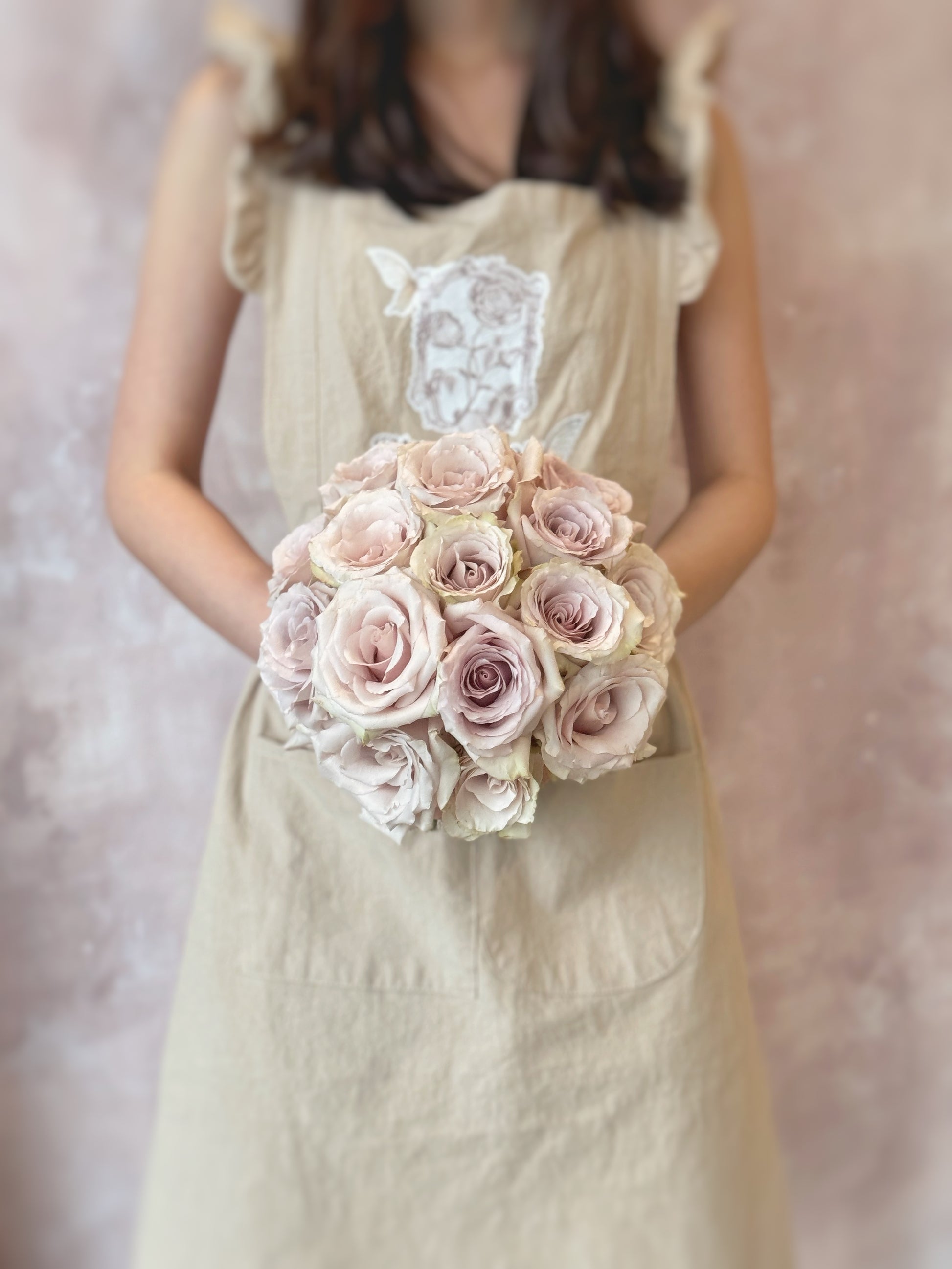 Only quicksand roses round shaped bridal_bouquet_holding by a model, Elegant bridal bouquet with soft quicksand roses in a perfectly round design, ideal for a romantic and refined wedding style