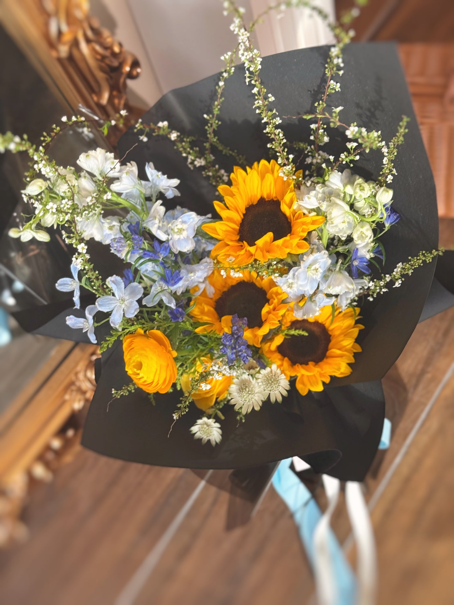 Close-up of sunflower centers and blue floral textures (blue delphinium, mini delphinium, ranunculus flower), emphasizing the bold contrast and detailed textures of each bloom.
特写镜头聚焦向日葵花心与蓝色花材纹理,对比鲜明,细节丰富。