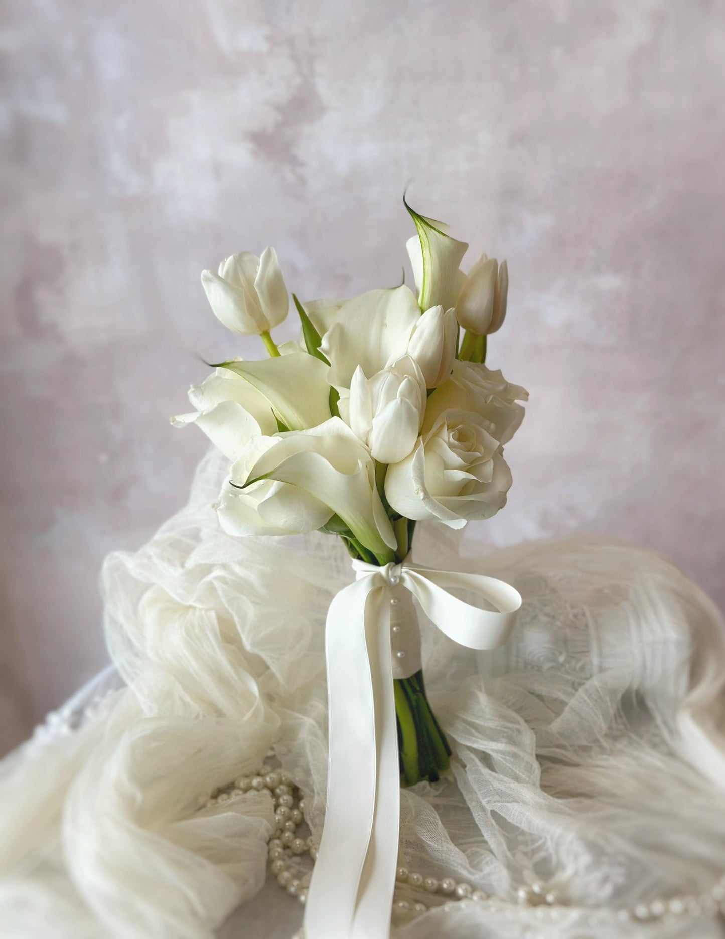 A premium white bridal bouquet featuring calla lilies, tulips, and roses for a timeless elegant look
经典优雅的白色新娘捧花,融合马蹄莲、郁金香和玫瑰,展现永恒之美