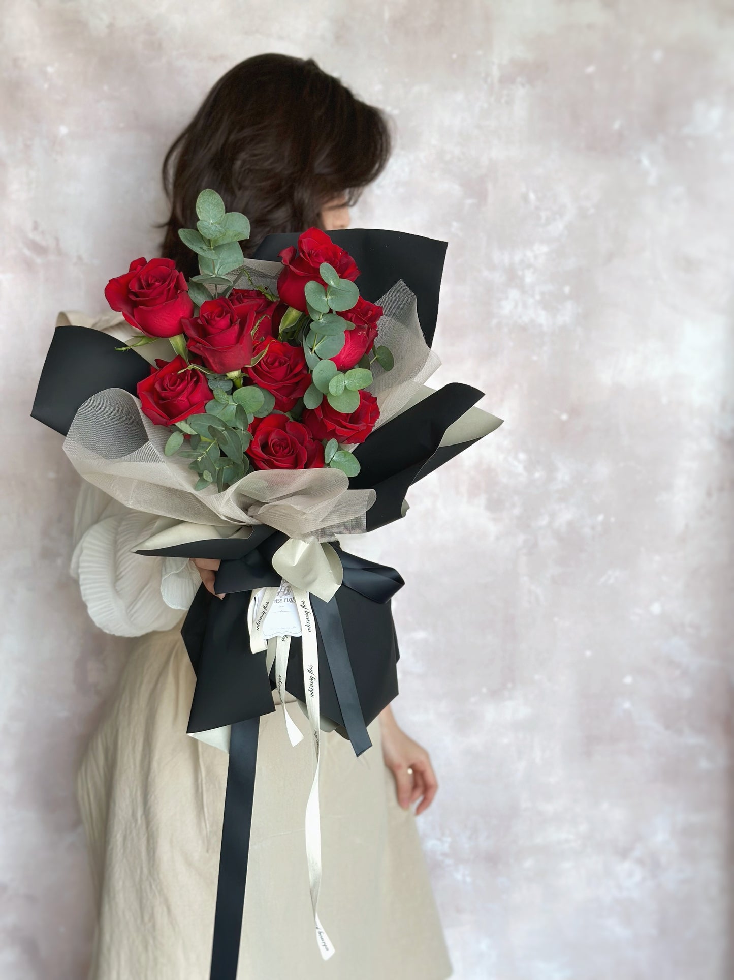 Model holding the bouquet in front of her, highlighting the bold red blooms and the striking black and khaki wrap — a modern romantic gesture.
模特手持花束,鲜红玫瑰与黑卡其包装形成对比,现代感十足的浪漫表达。