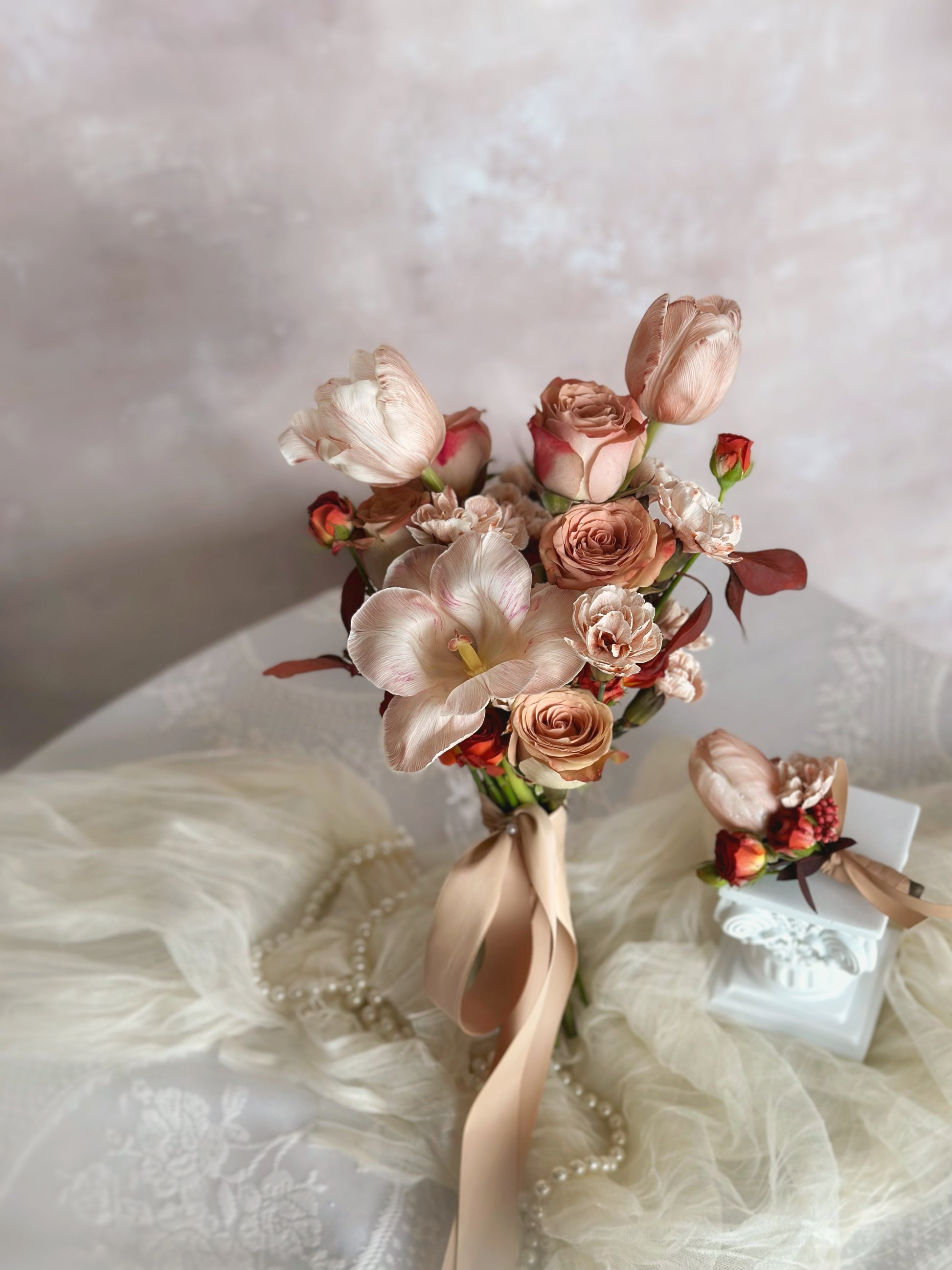 A fall-themed tulip bridal bouquet with a matching groom's tulip corsage in blush and brown hues
秋季主题郁金香新娘捧花,搭配柔粉与棕色系同款胸花