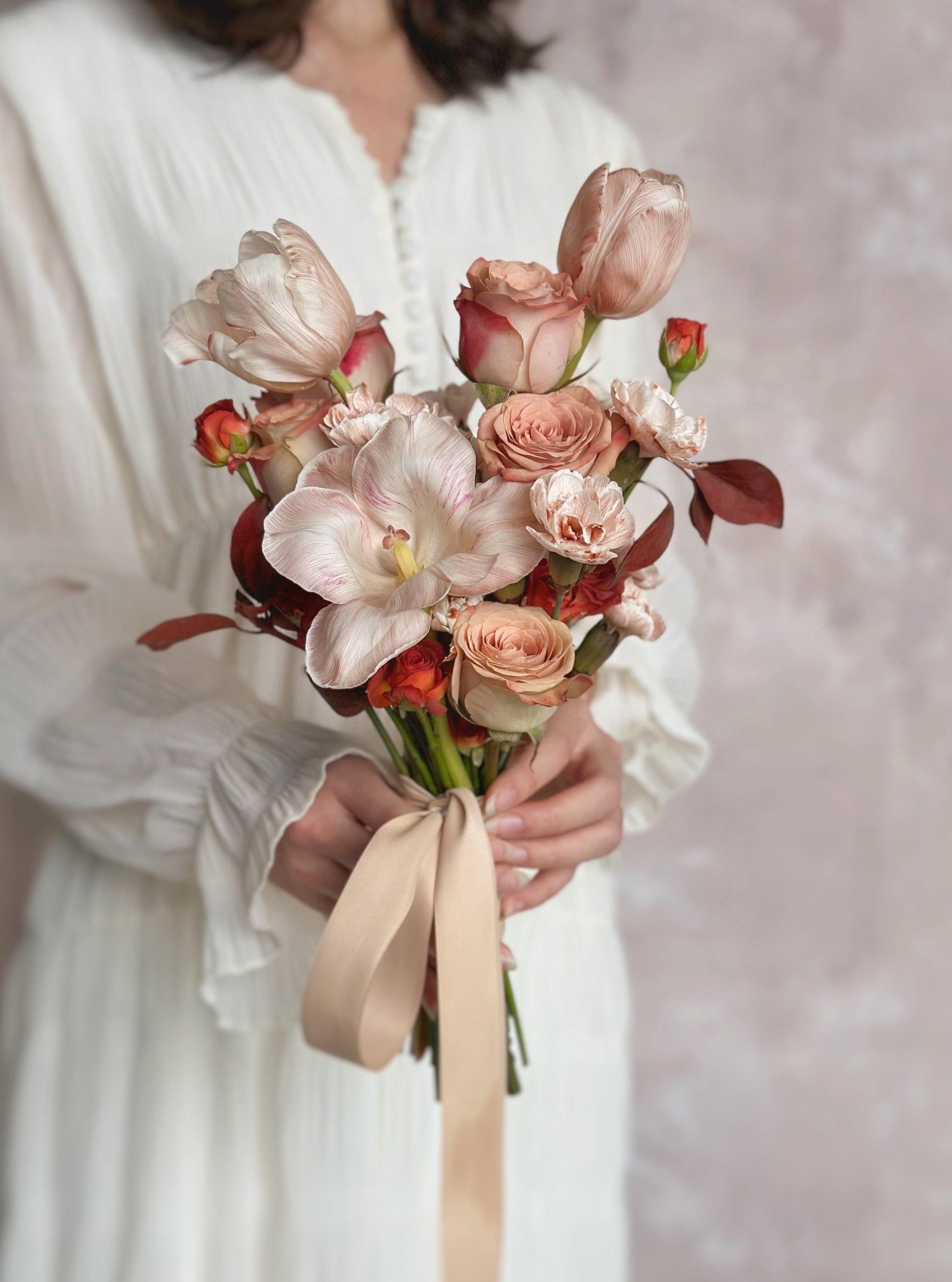 unique hand-tied bouquet featuring maroon foliage, cappuccino roses, chocolate bubble roses and stem-dyed tulips in warm autumn shades
手扎式郁金香玫瑰捧花,采用茎染工艺呈现温暖秋季色调
