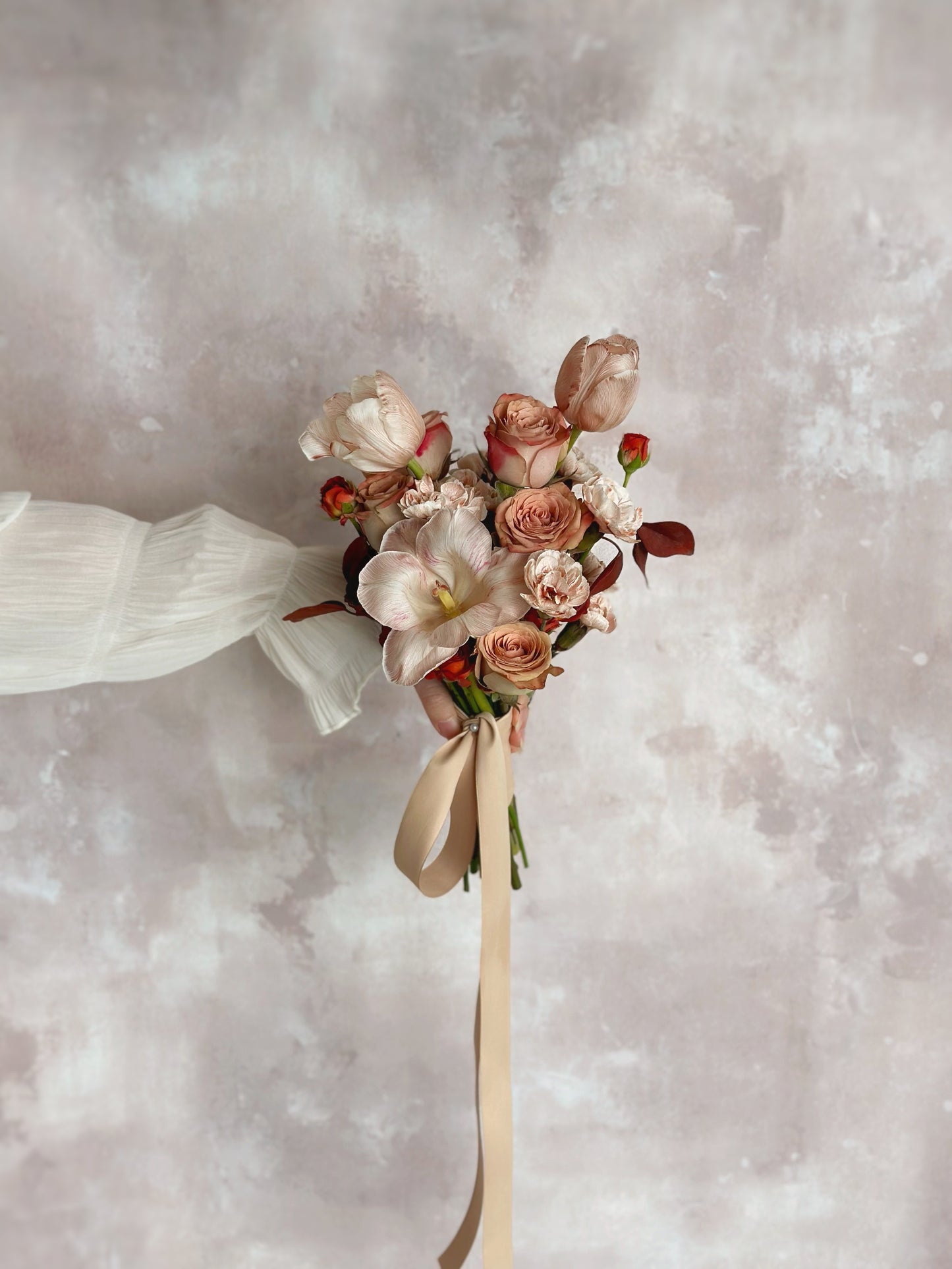 A delicate mix of soft blush and maroon tulips for a feminine bridal look
柔粉与栗色郁金香交织,打造温柔浪漫的新娘造型