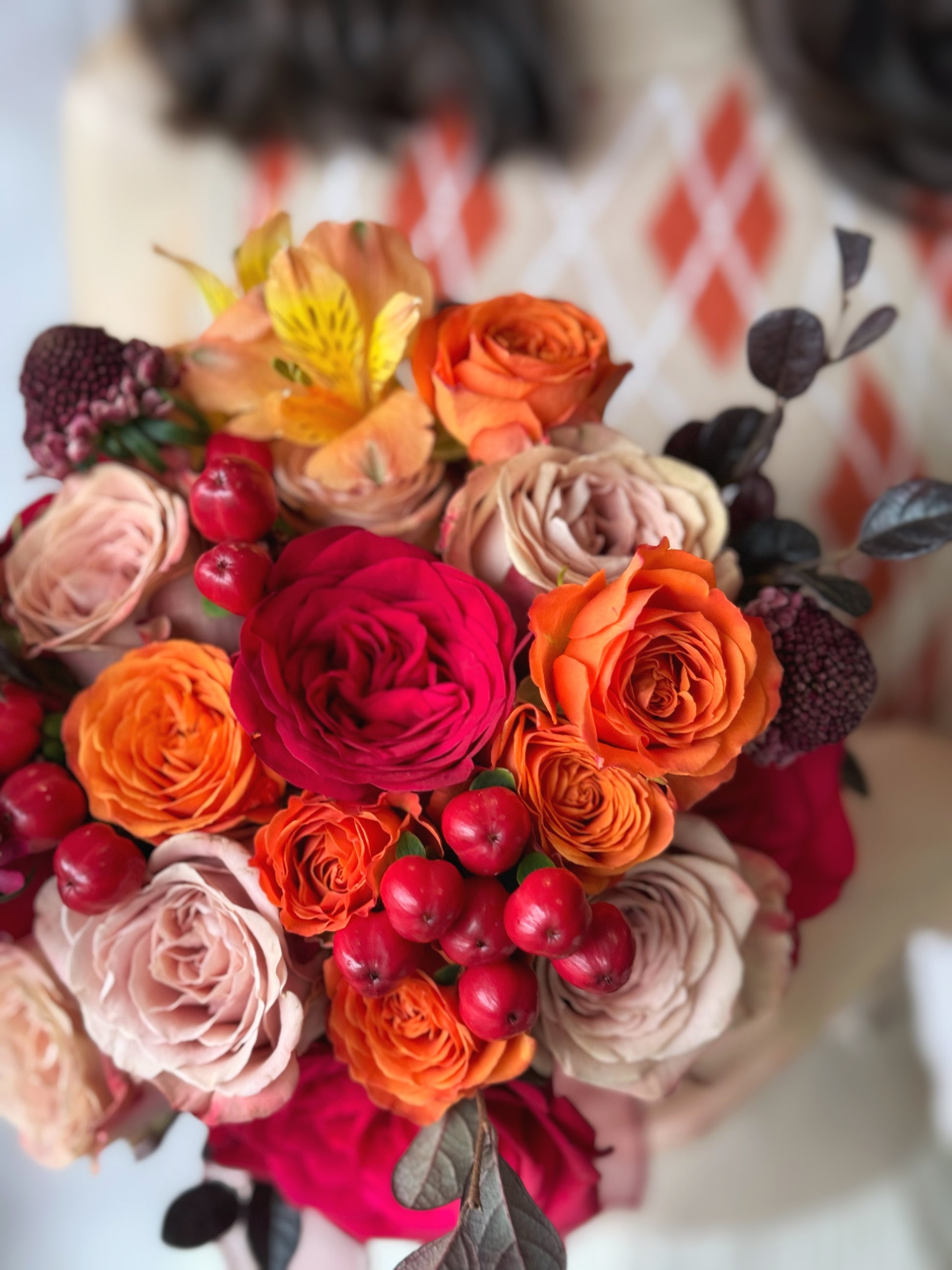 Close up view of a perfectly round-shaped bridal bouquet with rich orange and red roses, creating a warm and romantic aesthetic.
夕阳灵感捧花的特写,展现火红与暖橙玫瑰的完美融合
