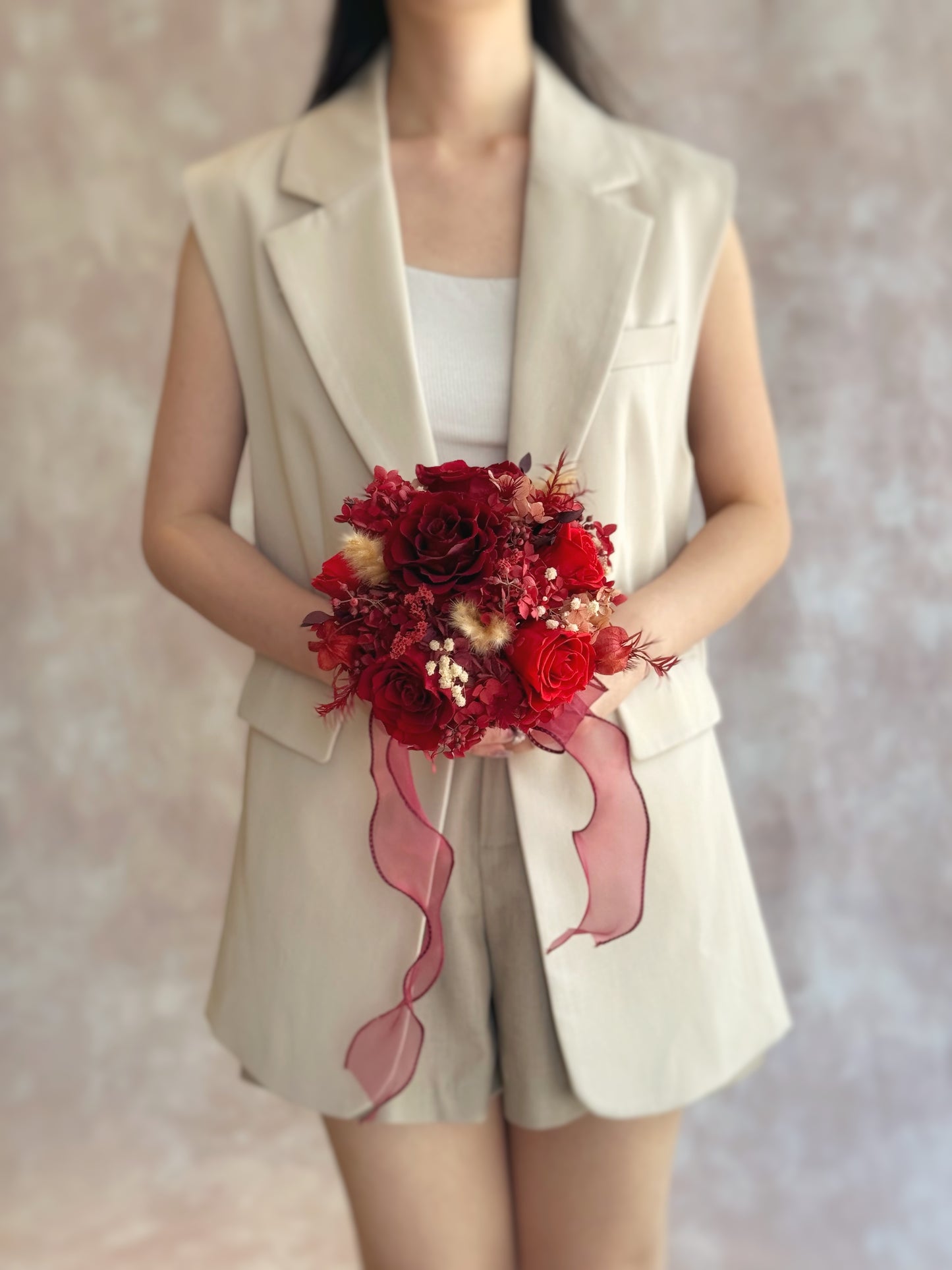 Top-down view showing symmetrical arrangement of deep red and cream preserved roses in a round bridal design.
俯视图展示对称排列的永生玫瑰,酒红与奶油色调相互衬托,典雅大方