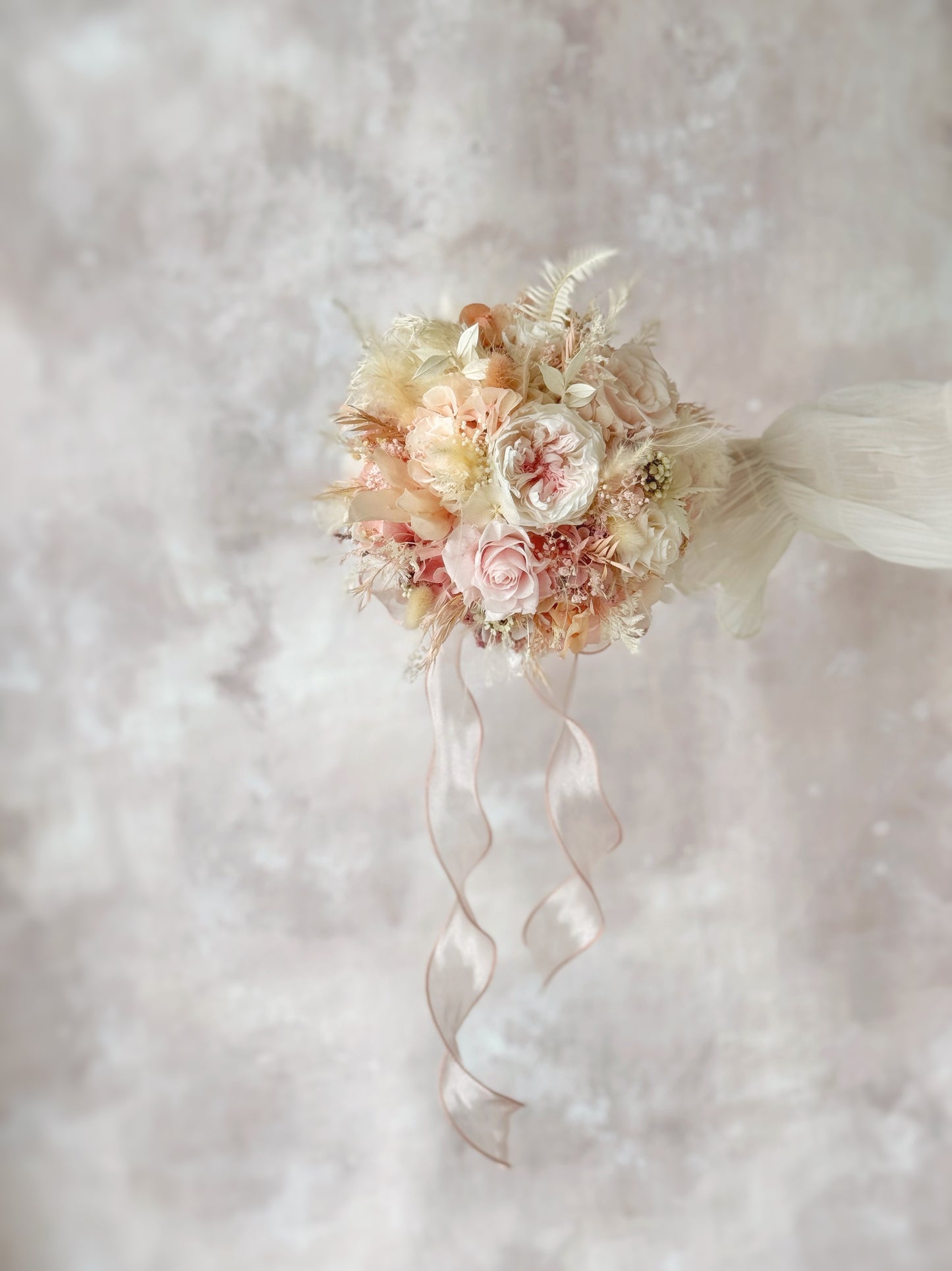 The bouquet’s soft color palette enhances the bride’s romantic and elegant look.
柔和的色彩搭配,完美衬托新娘的浪漫优雅造型。