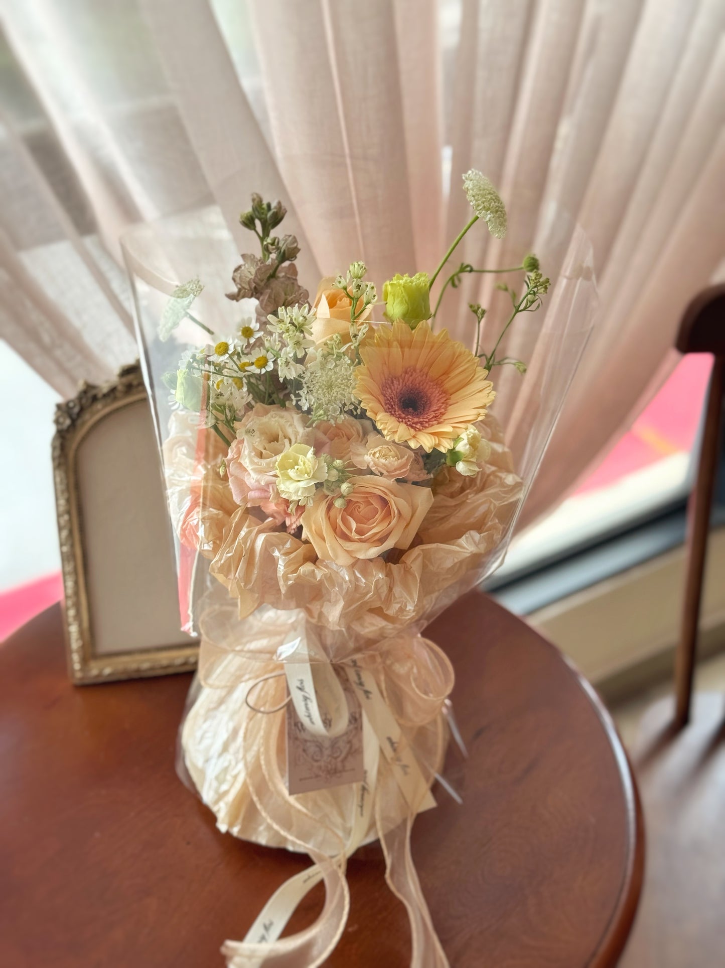 Earth-toned bouquet placed on a neutral-toned table, showing its soft structure and textured wrapping in a calm, serene setting.
花束置于浅色桌面,展现其柔和结构与纹理纸包裹,氛围宁静雅致