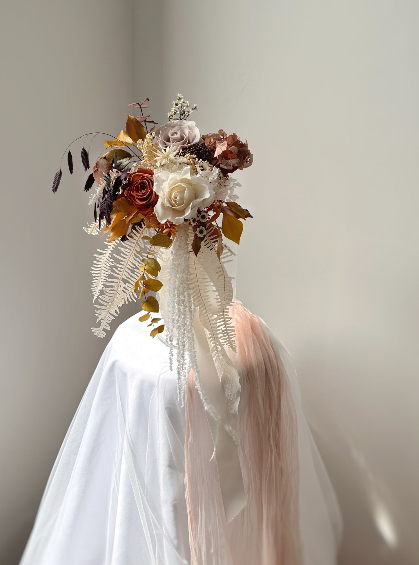 Long cascading preserved ferns and amaranthus create a graceful trailing effect.
长长的垂坠状蕨类与苋属花材,打造优雅飘逸的线条感。